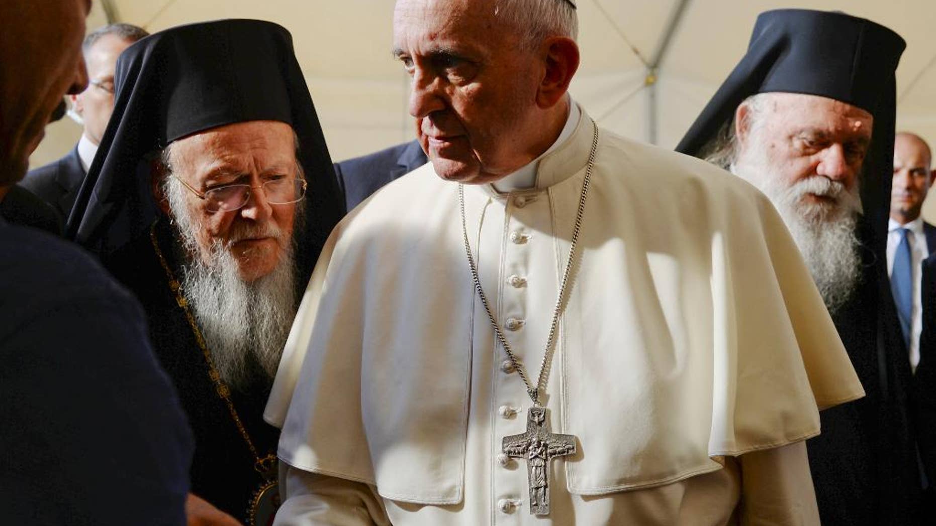 Pope Francis, center, is flanked by Ecumenical Patriarch Bartholomew I, spiritual leader of the world’s Orthodox Christians, left, and Archbishop of Athens and All Greece Ieronymos II as they meet refugees at the Moria camp, on the Greek island of Lesbos, Saturday, April 16, 2016. Pope Francis travelled Saturday to Greece for a brief but provocative visit to meet with refugees at a detention center as the European Union implements a controversial plan to deport them back to Turkey. (Filippo Monteforte/Pool Photo via AP)