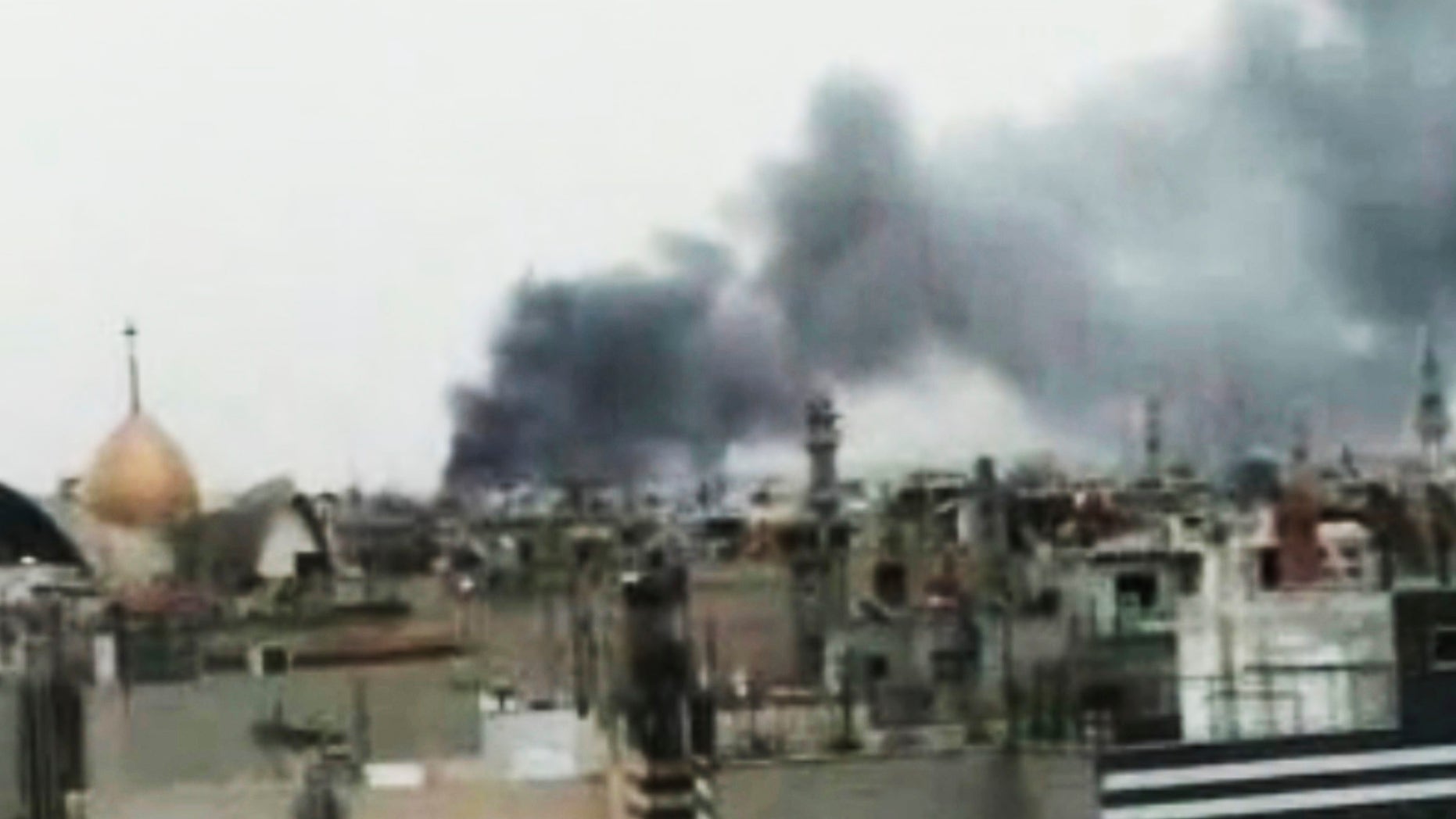 Monday, March 26: This image made from amateur video and released by Shaam News Network purports to show smoke rising from buildings in Homs, Syria. Syrian troops shelled rebel-held neighborhoods in the central city of Homs on Monday with at least five people seriously wounded.