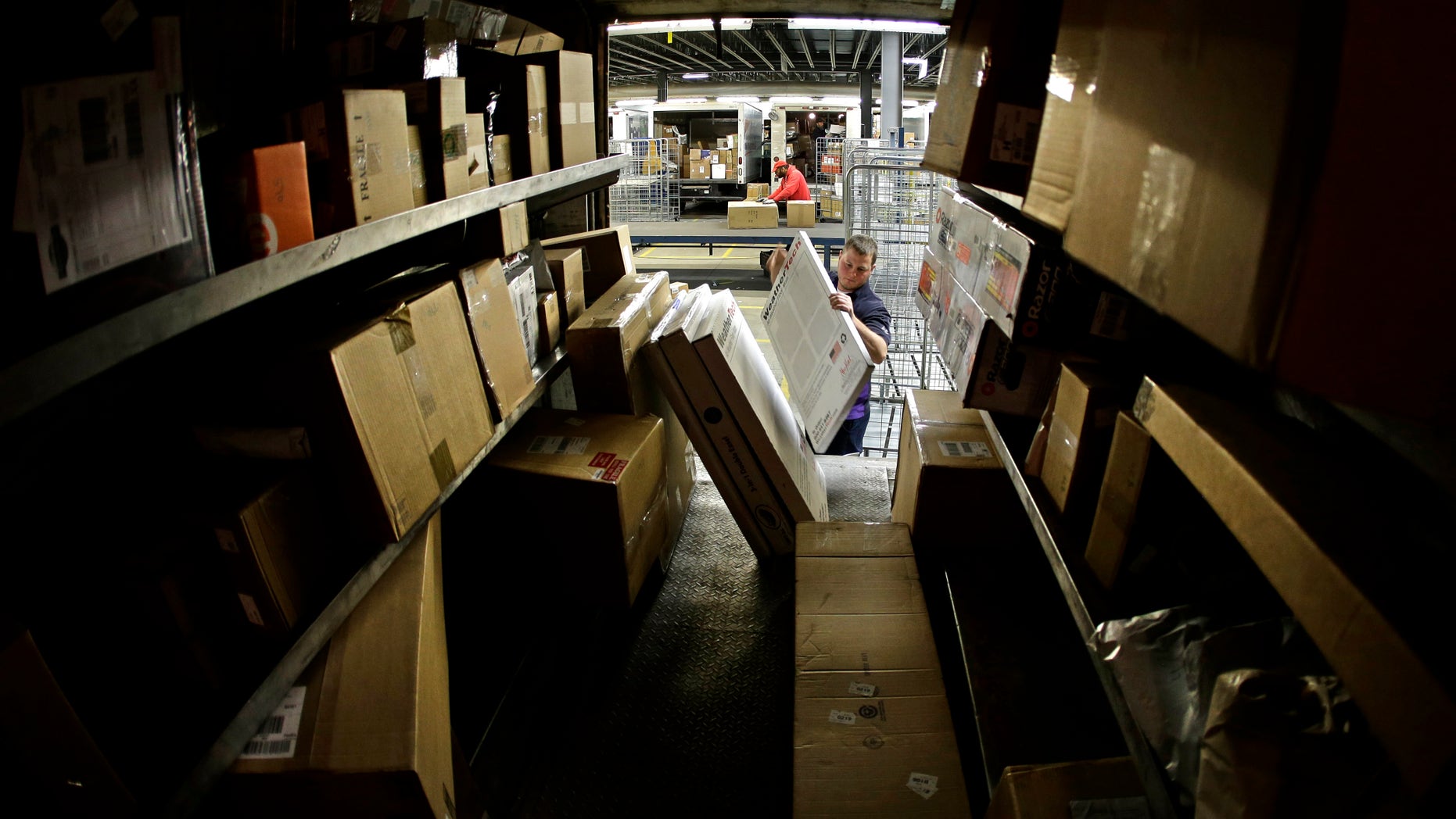 FILE - In this Monday, Dec. 16, 2013, file photo, driver Kyle Woodroof loads packages in his delivery truck in Kansas City, Mo. The Commerce Department reports on U.S. factory orders in December on Tuesday, Feb. 4, 2014. (AP Photo/Charlie Riedel, File)