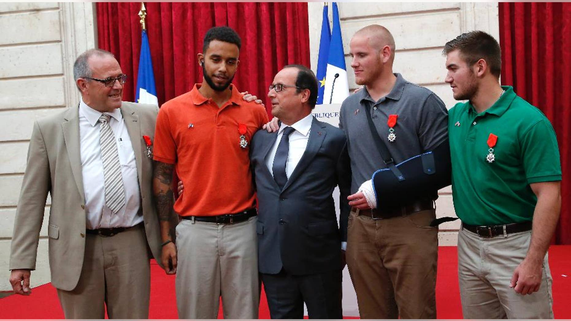 CORRECTS SADLER’S SCHOOL TO SACRAMENTO STATE UNIVERSITY, INSTEAD OF SACRAMENTO UNIVERSITY - From the left, British businessman Chris Norman, Anthony Sadler, a senior at Sacramento State University in California, French President Francois Hollande, U.S. Airman Spencer Stone, and Alek Skarlatos a U.S. National Guardsman from Roseburg, Ore., pose at the Elysee Palace, Monday, Aug. 24, 2015 in Paris, France. Hollande pinned the Legion of Honor medal on Stone, Skarlatos and Sadler, three long-time friends who subdued a gunman on Friday, Aug. 21, as he moved through a speeding train with an assault rifle strapped to his bare chest. Norman also jumped into the fray. (AP Photo/Michel Euler, Pool)