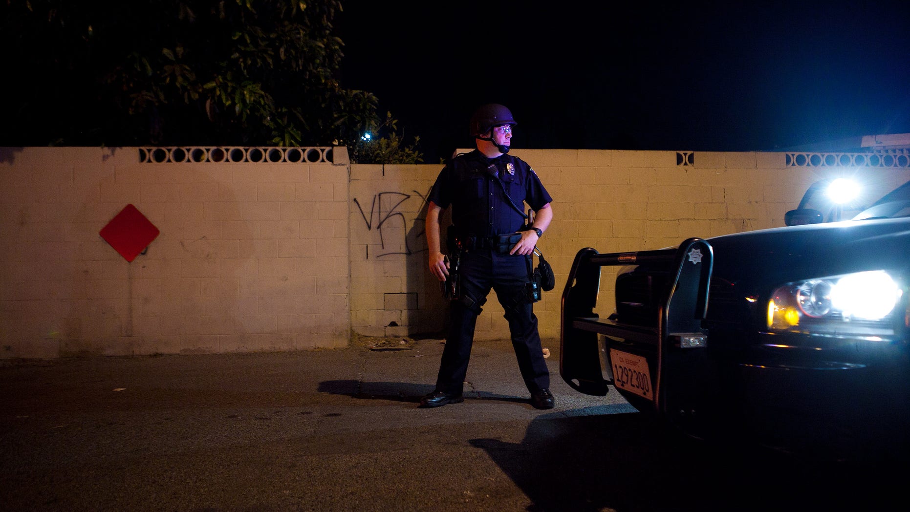 ANAHEIM, CA - JULY 25: A police officer stands guard after protesters set fire to a near by trash bin during a demonstration to show outrage for the fatal shooting of Manuel Angel Diaz, 25, at Anaheim City Hall on July 24, 2012 in Anaheim, California. Diaz was fatally shot on July 21 by an Anaheim police officer and has sparked days of protests by the angered community. (Photo by Jonathan Gibby/Getty Images)
