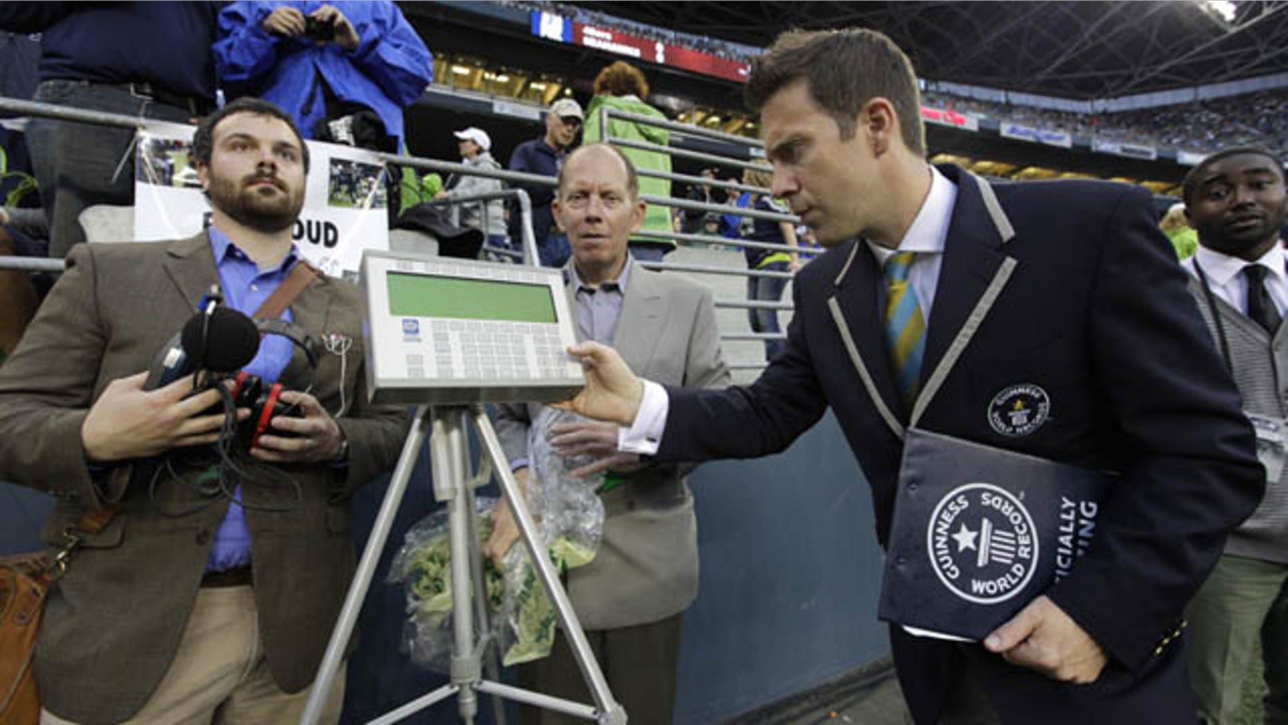 September 15, 2013: Philip Robertson, right, an adjudicator with Guinness World Records, examines a device used to measure the sound level of cheering fans at CenturyLink Field in Seattle prior to an NFL football game between the Seattle Seahawks and the San Francisco 49ers. (AP Photo)