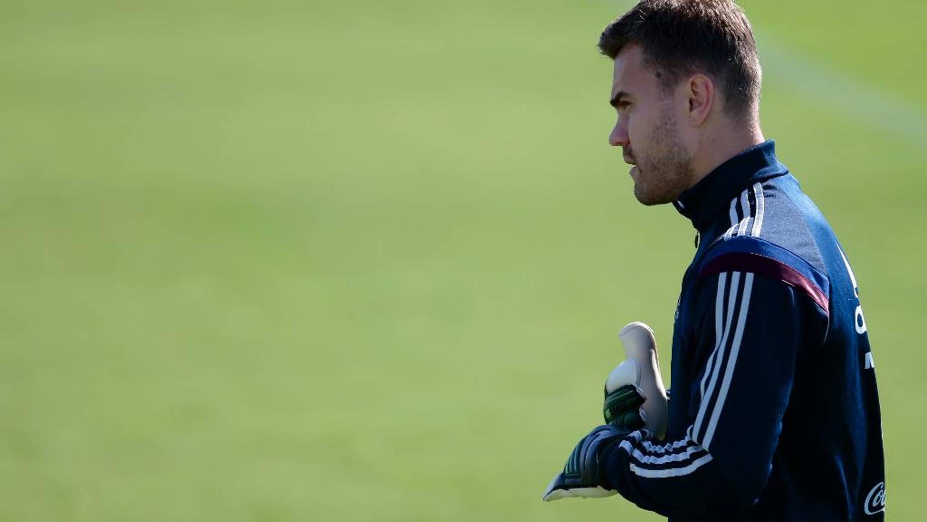 Goalkeeper Igor Akinfeev looks at a ball during Russian national soccer team training session in Itu, Brazil, on Thursday, June 19, 2014. Russia will play next game against Belgium in group H of the 2014 soccer World Cup. (AP Photo/Ivan Sekretarev)