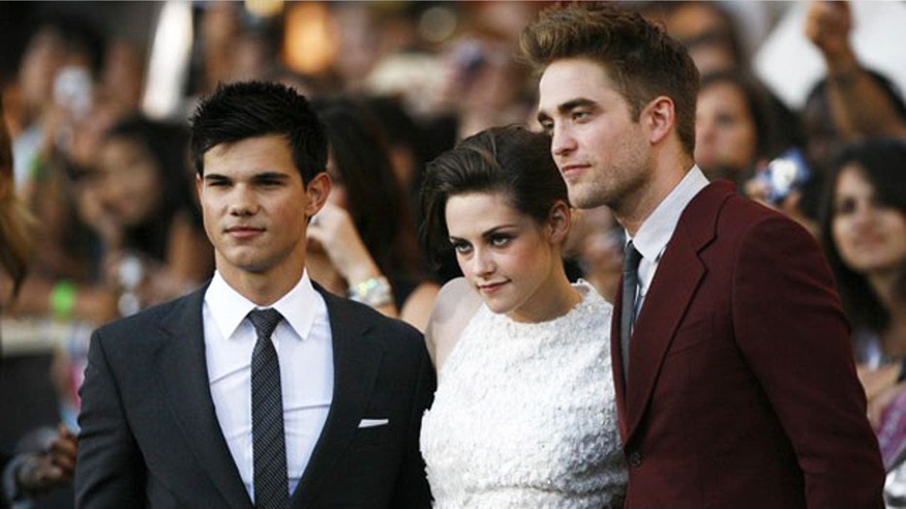 June 24: 'Twilight' stars Taylor Lautner, Kristen Stewart and Robert Pattinson pose for cameras at the premiere of the film.