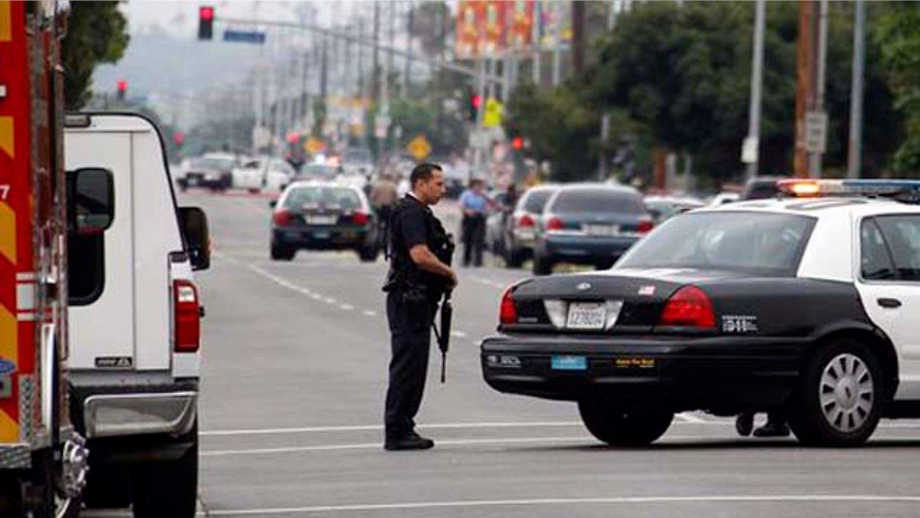 June 25, 2013: Los Angeles police officers close off and search a city street after two police officers were shot and wounded in an attack outside a police station in the Mid-City area of Los Angeles.