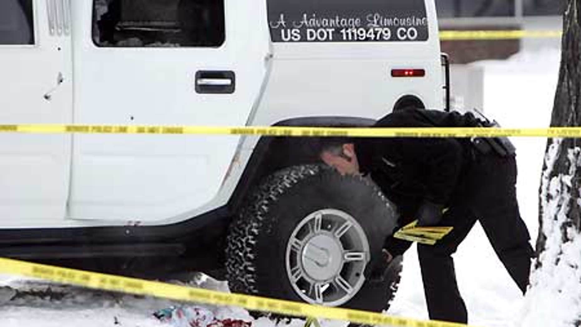 Jan. 1, 2007: An investigator with the Denver Police Department places evidence markers next to the Hummer limo in which Darrent Williams was killed.