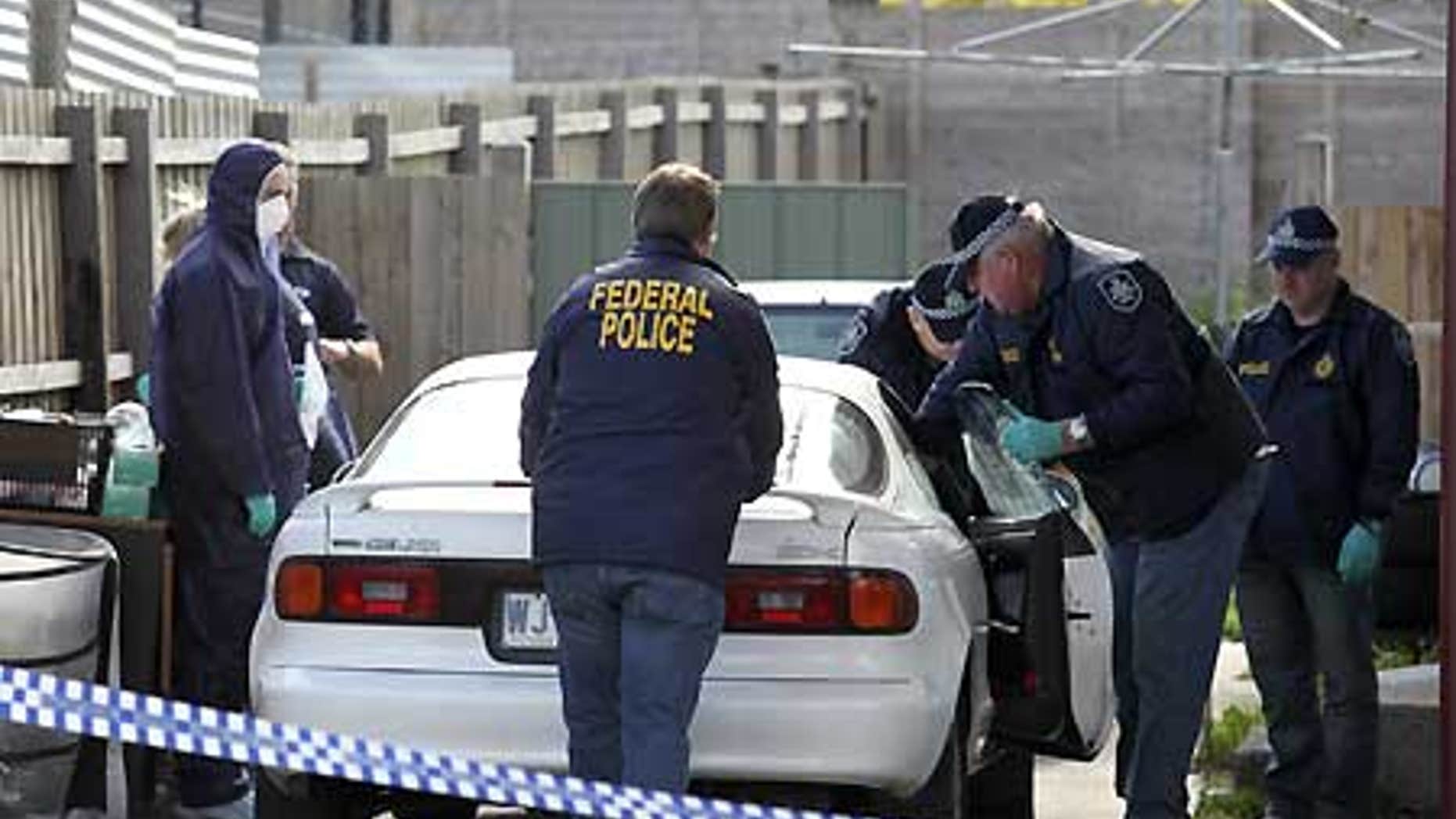 Aug. 4: Police search a car at a Melbourne suburb after a pre-dawn raid at one of 19 locations.