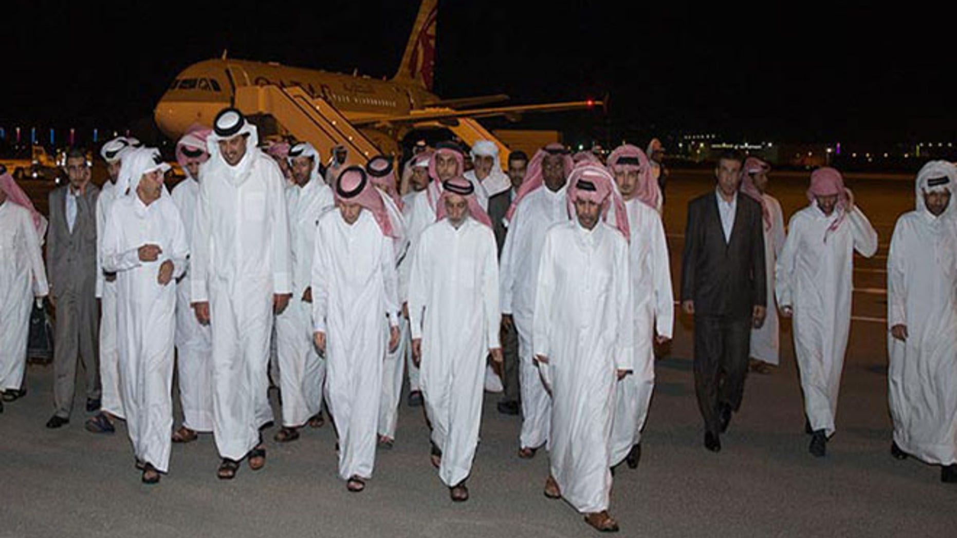 In this photo released by Qatar News Agency, Emir of Qatar Sheikh Tamim bin Hamad Al Thani, second left in front row, receives the released Qataris at the Doha airport in Doha, Qatar Friday, April 21, 2017.