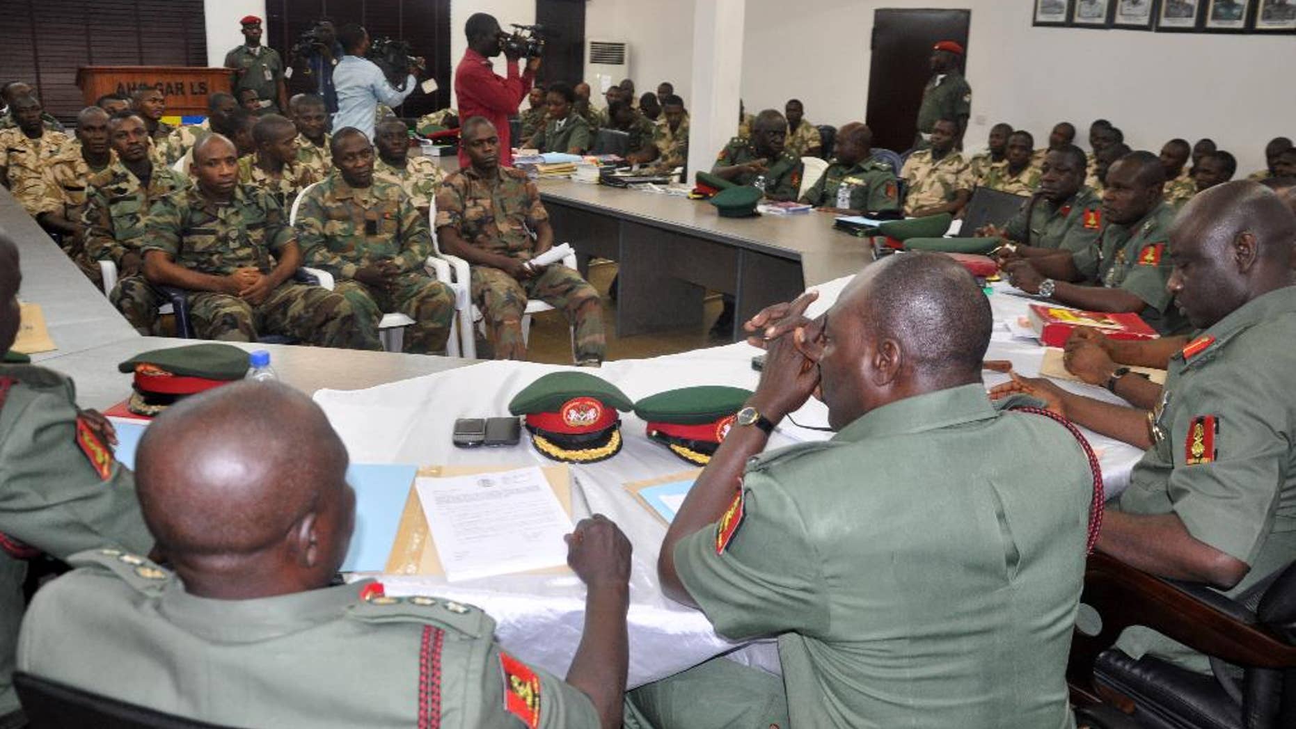 FILE - In this Wednesday Oct. 15, 2014 file photo, soldiers accused of refusing to fight in the country's northeastern Islamic uprising appear before a court martial in Abuja, Nigeria. Nearly 600 Nigerian officers and troops faced charges before a court-martial Wednesday May 20, 2015, the army said of an unprecedented number of soldiers believed to be on trial for alleged offenses related to the ongoing fight against an Islamic uprising in the northeast. (AP Photo/Olamikan Gbemiga, File)