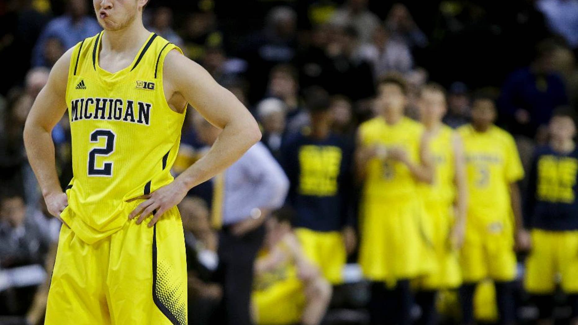 Michigan's Spike Albrecht (2) reacts as Villanova's Ryan Arcidiacono shoots a free throw during the second half of an NCAA college basketball game Wednesday, Nov. 26, 2014, in New York. Villanova won the game 60-55. (AP Photo/Frank Franklin II)
