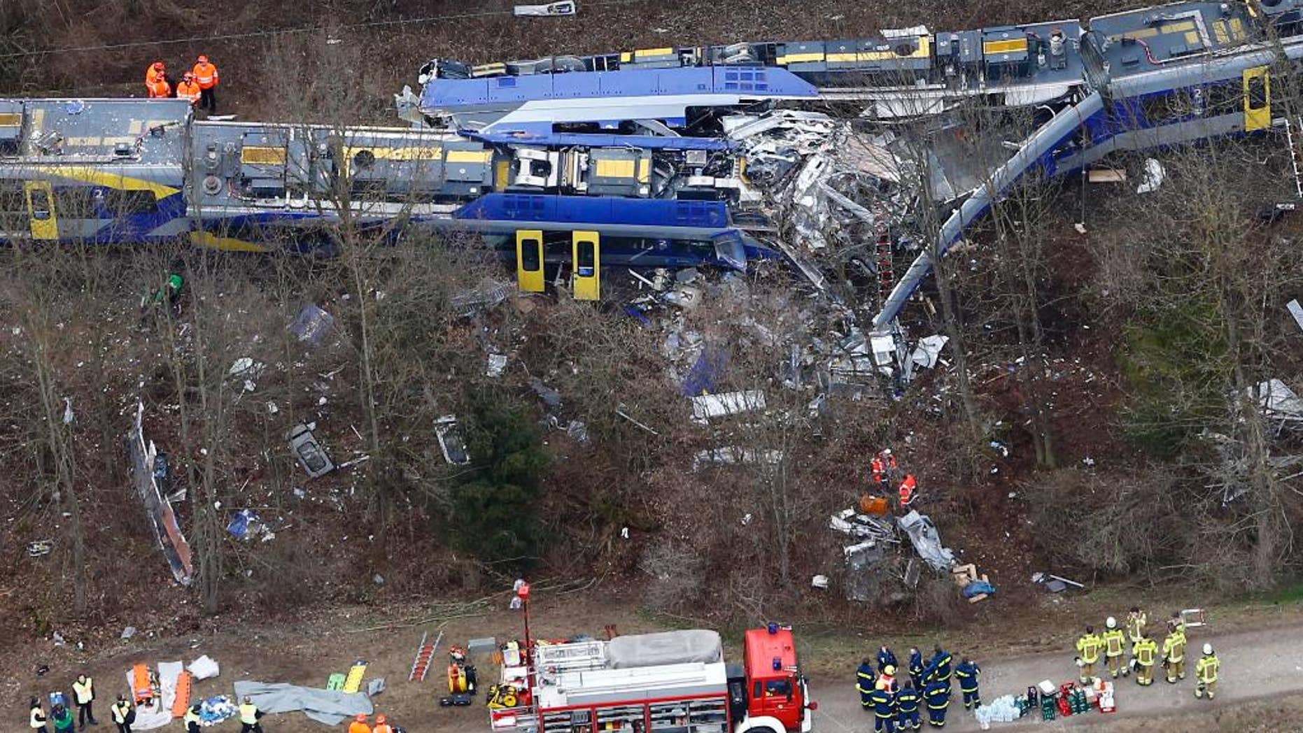 FILE - In this Feb. 9, 2016 file photo rescue teams work at the site where two trains collided head-on near Bad Aibling, Germany, killing twelve people and injuring 89. On Monday, Dec. 5, 2016 the train dispatcher was sentenced to 3 years and six months in prison because of negligence that led to one of the worst train crashes in German history this year. (AP Photo/Matthias Schrader, file)
