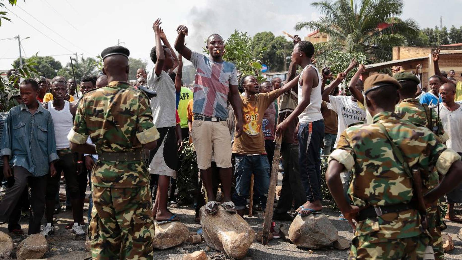 FILE - In this May 27, 2015 file photo, opposition demonstrators confront army soldiers in the Mutarakura district, as security forces try to prevent people moving out of their neighborhoods, in the capital Bujumbura, Burundi. A global human rights umbrella organization issued a report on Tuesday, Nov. 15, 2016, urging Africa, Europe and the United Nations to send a civilian protection force to Burundi to prevent a possible civil war and genocide. (AP Photo/Gildas Ngingo, File)