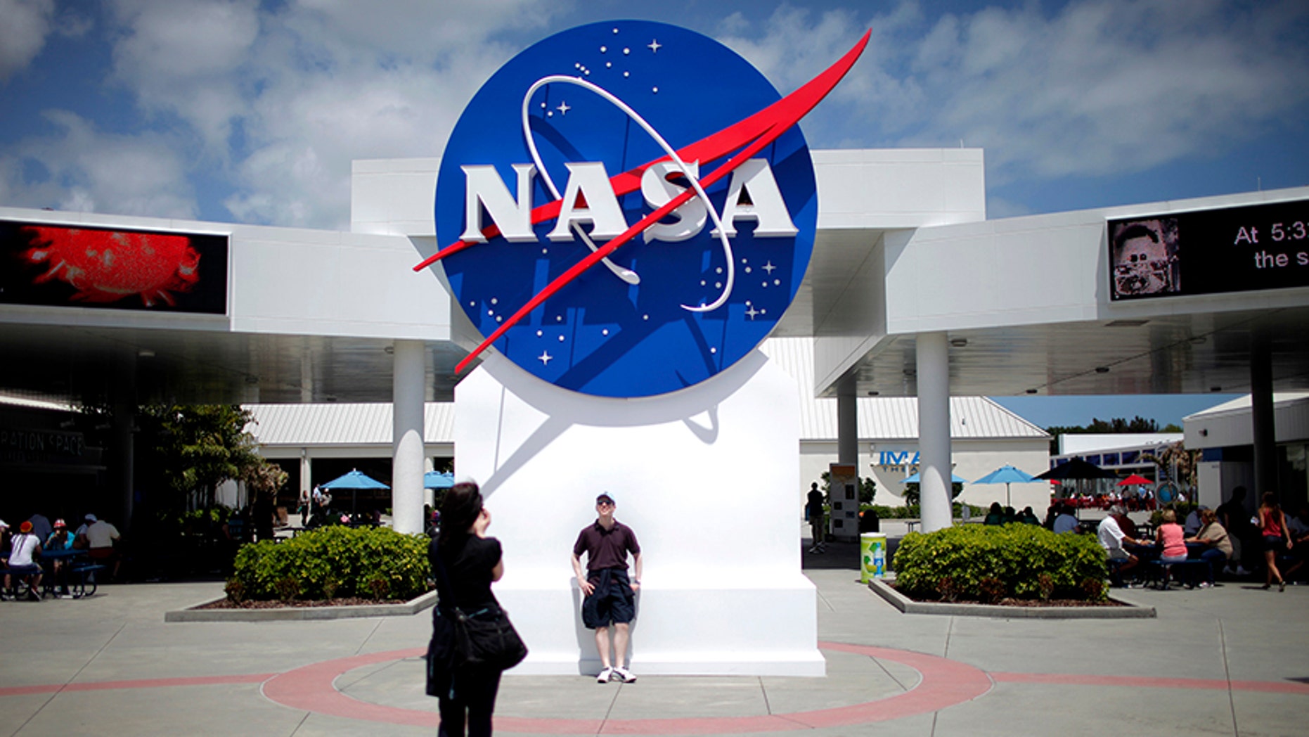 April 14, 2010: Tourists take pictures of a NASA sign at the Kennedy Space Center visitors complex in Cape Canaveral, Florida.