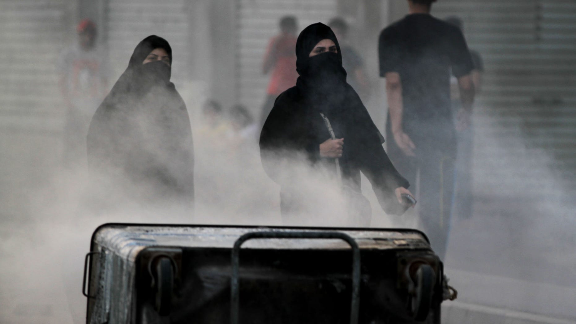 Bahraini anti-government protesters block a road with burning debris to slow approaching riot police in Sanabis, Bahrain, Monday, April 15, 2013. The race is to be held Sunday. Bahrain's government has backed proposals to impose penalties of up five years in prison for insulting the Gulf state's king or its national symbols, the media said Monday. (AP Photo/Hasan Jamali)