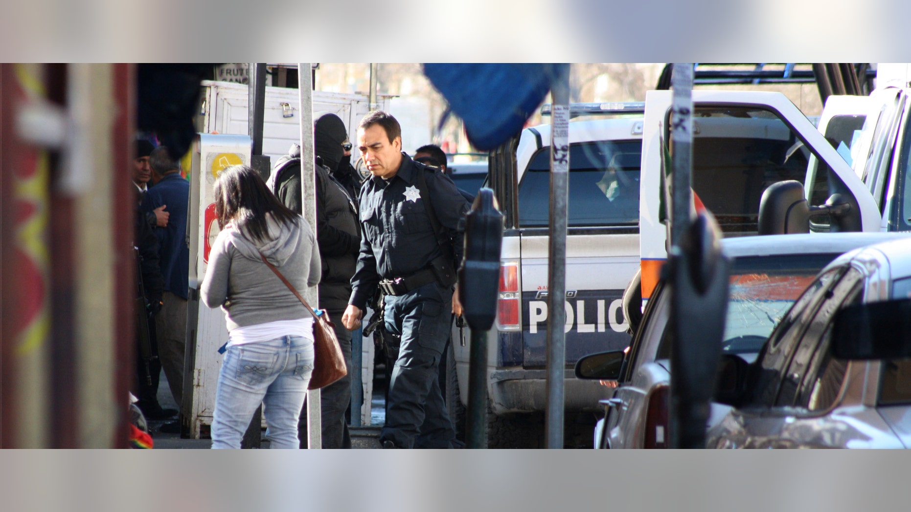 The police chief of the northern border city of Ciudad Juarez, Julian Leyzaola, center, walks past the body of a top municipal police officer after he was gunned down by unknown attackers in Ciudad Juarez, Mexico, Tuesday Jan. 10, 2012. According to local media reports, another officer and an unconfirmed number of civilians were injured. (AP Photo/Raymundo Ruiz)