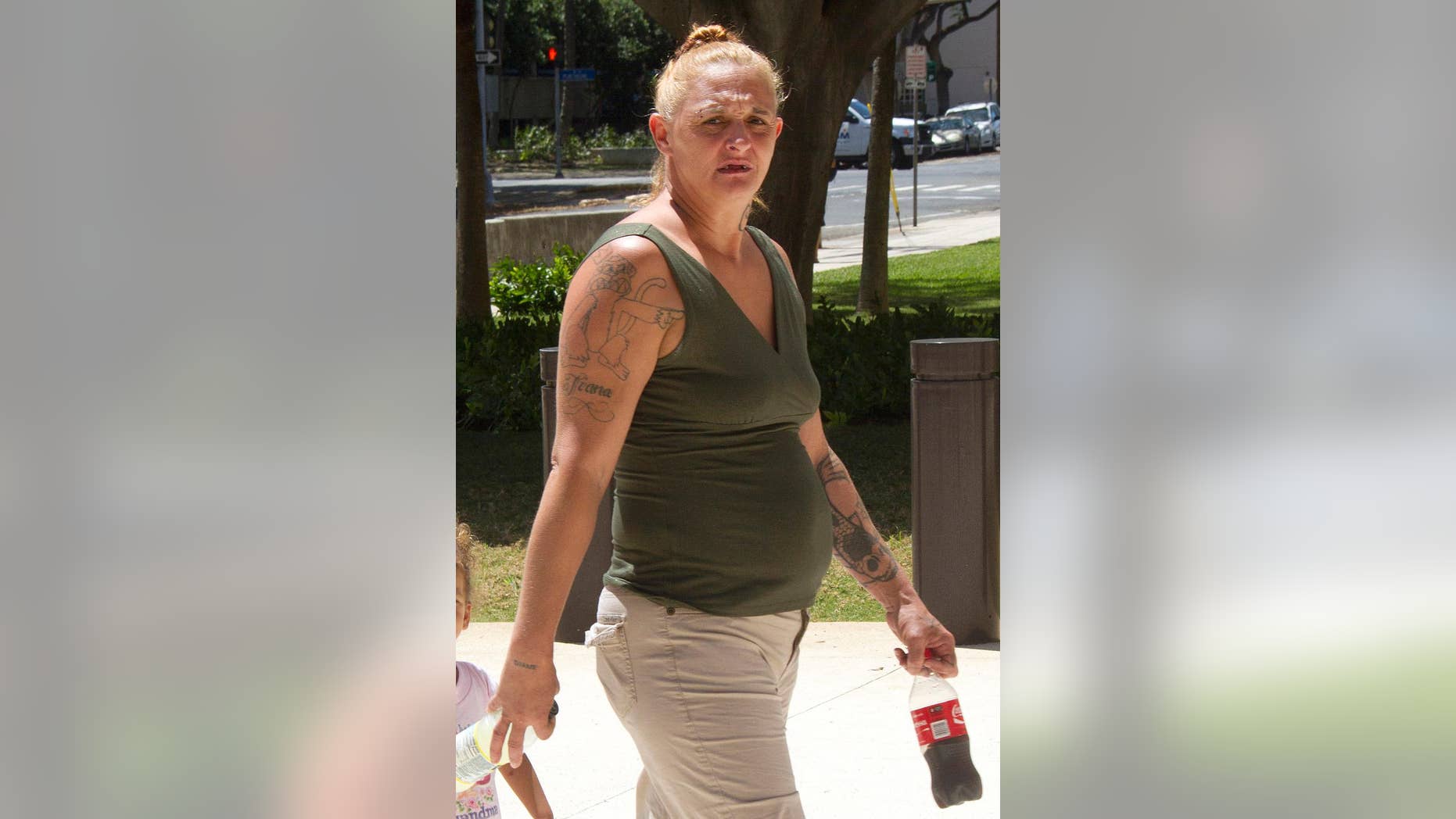 FILE - In this May 22, 2015 file photo, Samantha Leialoha Watanabe walks outside of federal court in Honolulu. Jurors are deliberating, Monday, Dec. 7, 2015, whether Watanabe is guilty of assaulting her 15-month-old daughter during a flight from Alaska to Honolulu on May 3, 2015. Prosecutors say Watanabe cursed at her daughter Clementine, smacked her in the head, hit her in the face with a stuffed doll and yanked out tufts of her hair. They say passengers and flight attendants on the May 3 Alaska Airlines flight believed Watanabe was unnecessarily rough to a generally well-behaved toddler. (Dennis Oda/Honolulu Star-Advertiser via AP, File)