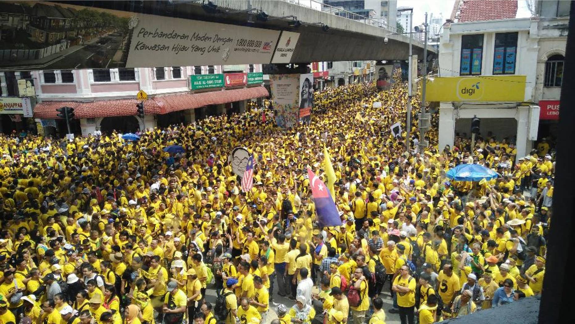Protesters occupy a street during a rally in downtown Kuala Lumpur, Malaysia, Saturday, Nov. 19, 2016. Tens of thousands of yellow-shirt protesters rallied Saturday in Kuala Lumpur seeking Malaysian Prime Minister Najib Razak's resignation over a financial scandal, undeterred by a police ban and the arrest of more than a dozen activists. (AP Photo/Forest Chew)