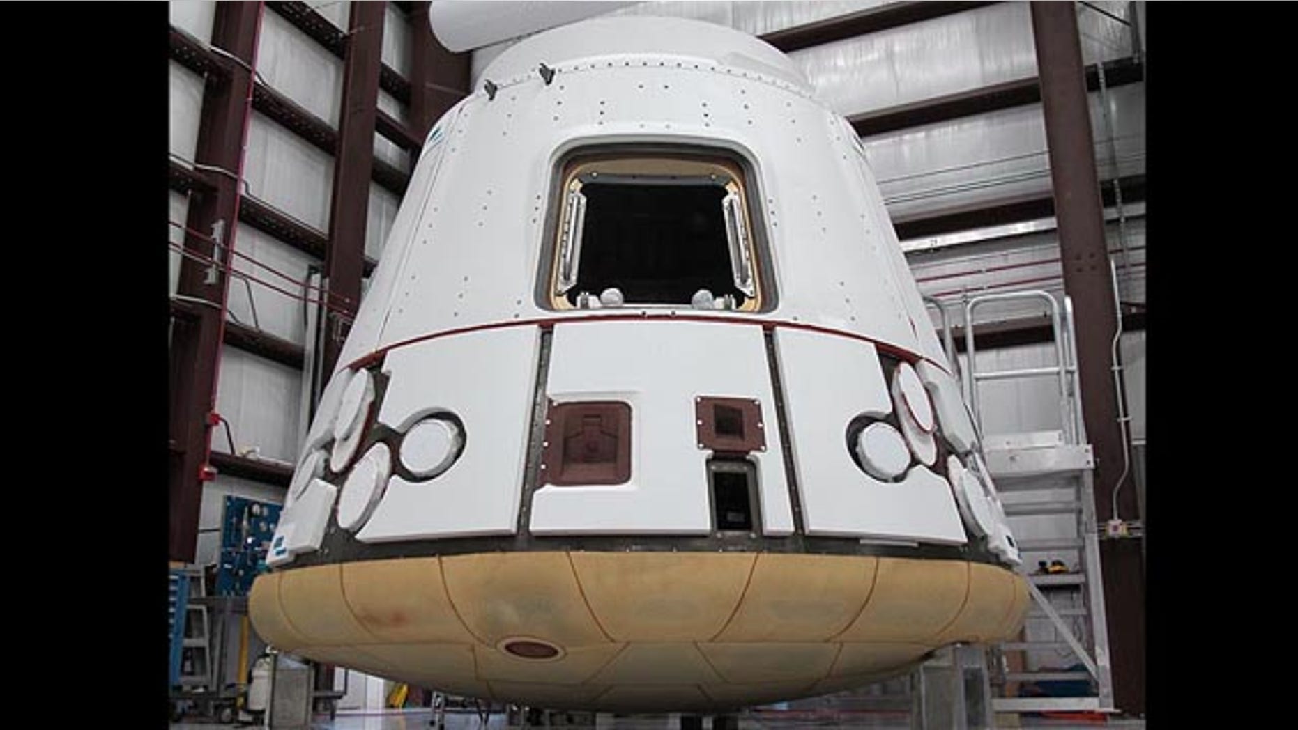 In the SpaceX hangar at Cape Canaveral, the Dragon spacecraft prepares for integration with the Falcon 9 launch vehicle. Visible at the base of the spacecraft is Dragon�s heat shield, made of PICA-X, the SpaceX manufactured variation on NASA�s Phenolic Impregnated Carbon Ablator (PICA) heat shield material. Dragon will reenter the Earth�s atmosphere at around 7 kilometers per second (15,660 miles per hour), heating the exterior up to 1850 degrees Celsius. However, just a few inches of the PICA-X material will keep the interior of the spacecraft at a comfortable temperature.