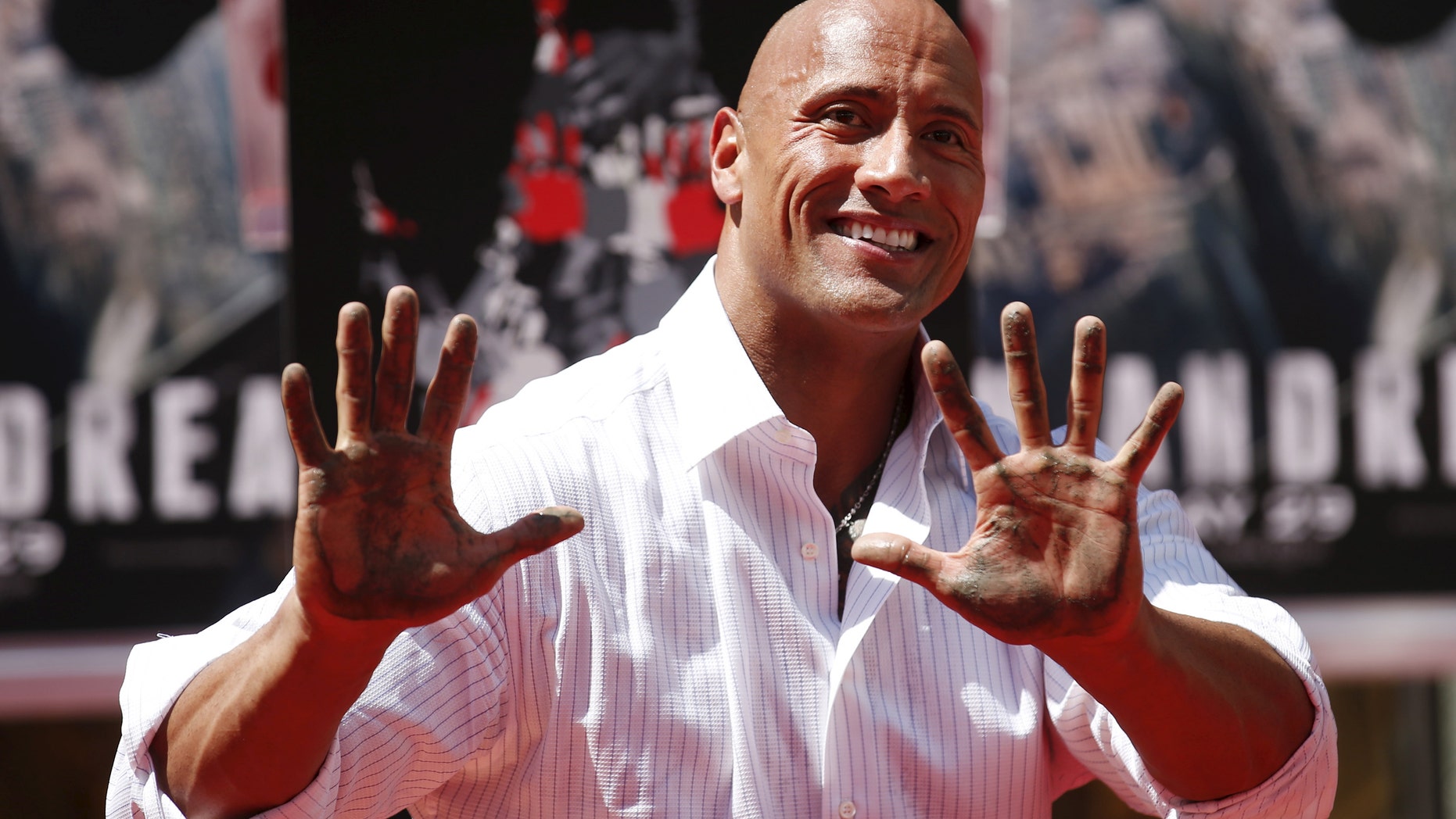 File photo - Actor Dwayne "The Rock" Johnson poses after putting his hands in cement during his hand and footprints ceremony in the forecourt of the TCL Chinese Theatre in celebration of his movie "San Andreas," in Hollywood, Calif. May 19, 2015. (REUTERS/Danny Moloshok)