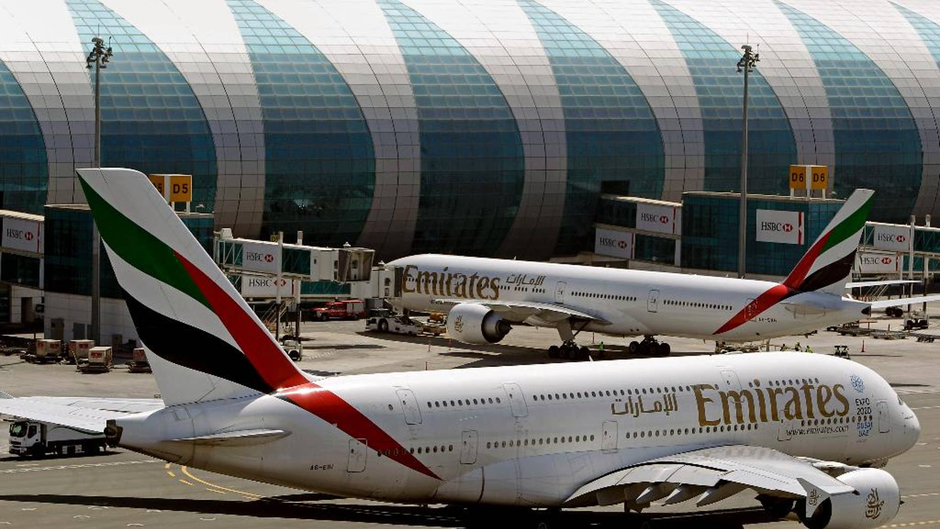 FILE- In this May 8, 2014 file photo, Emirates passenger planes are in use at Dubai airport in United Arab Emirates. Dubai Airports said Monday it plans to add 10 more A380 gates with air bridges at Dubai International Airport's Concourse C. That will leave the airport with a world record 47 gates designed for the aircraft. (AP Photo/Kamran Jebreili, File)