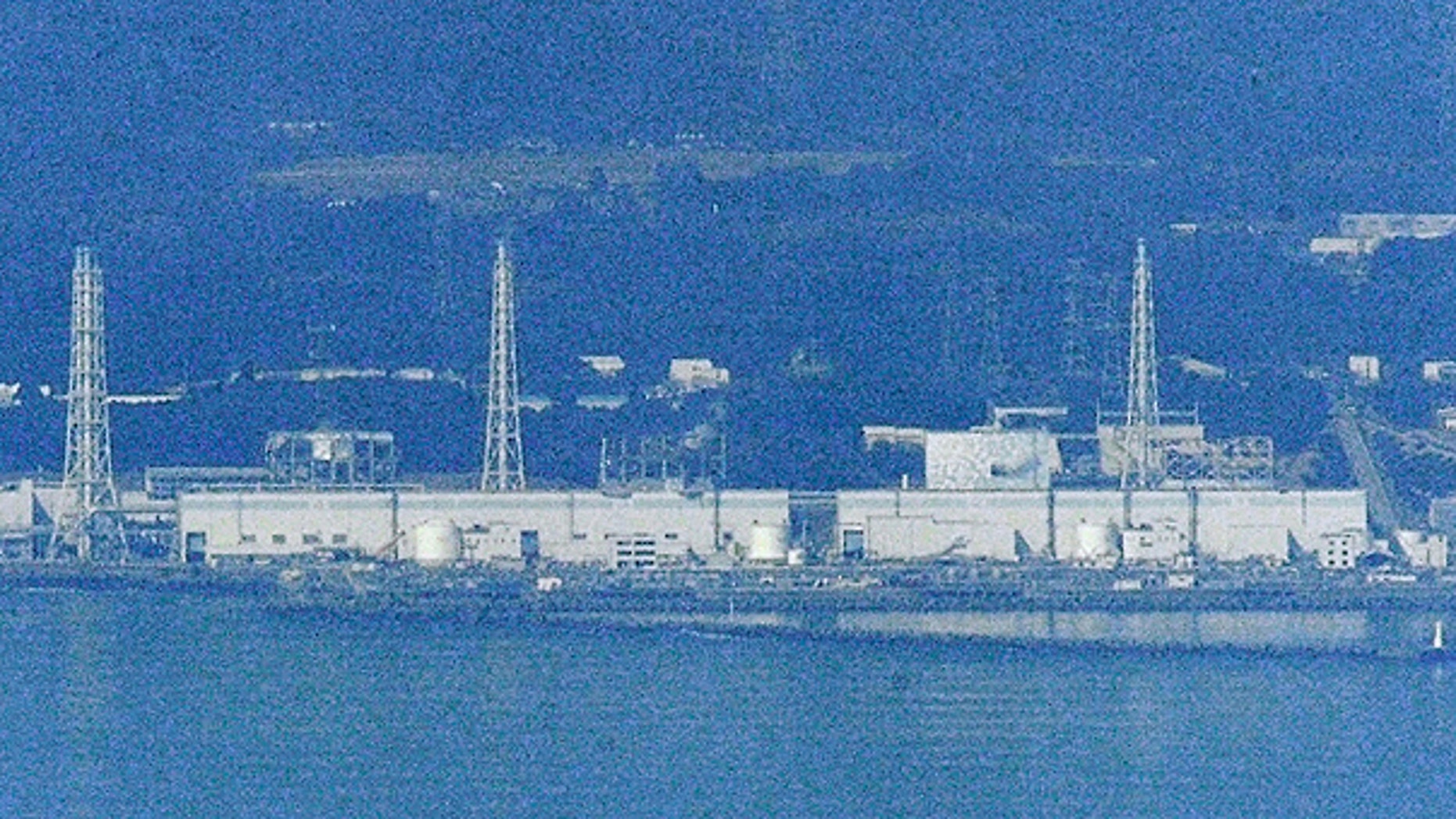 March 29: Only Unit 2 is covered with white concrete housing, seen on left of an iron tower on right, at the stricken Fukushima Dai-ichi nuclear power plant in Okumamachi, Fukushima prefecture.