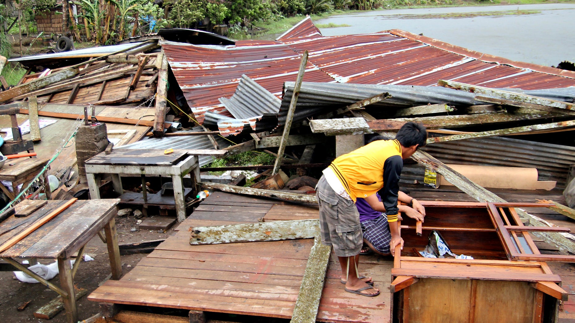 Dec. 4, 2012: Residents prepare to assess their house which was damaged by Typhoon Bopha in Butuan city in southeastern Philippines.