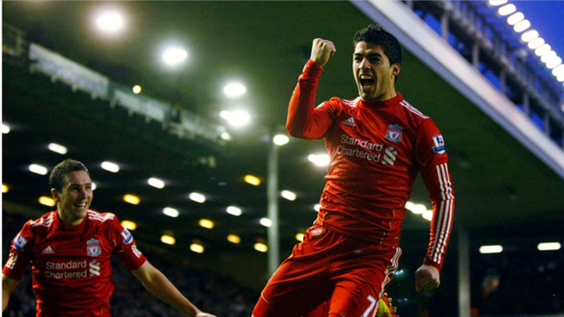 Liverpool's Luis Suarez, right, celebrates with teammate Stewart Downing after scoring a goal against Queens Park Rangers during their English Premier League soccer match at Anfield, Liverpool, England, Saturday Dec. 10, 2011. (AP Photo/Tim Hales)