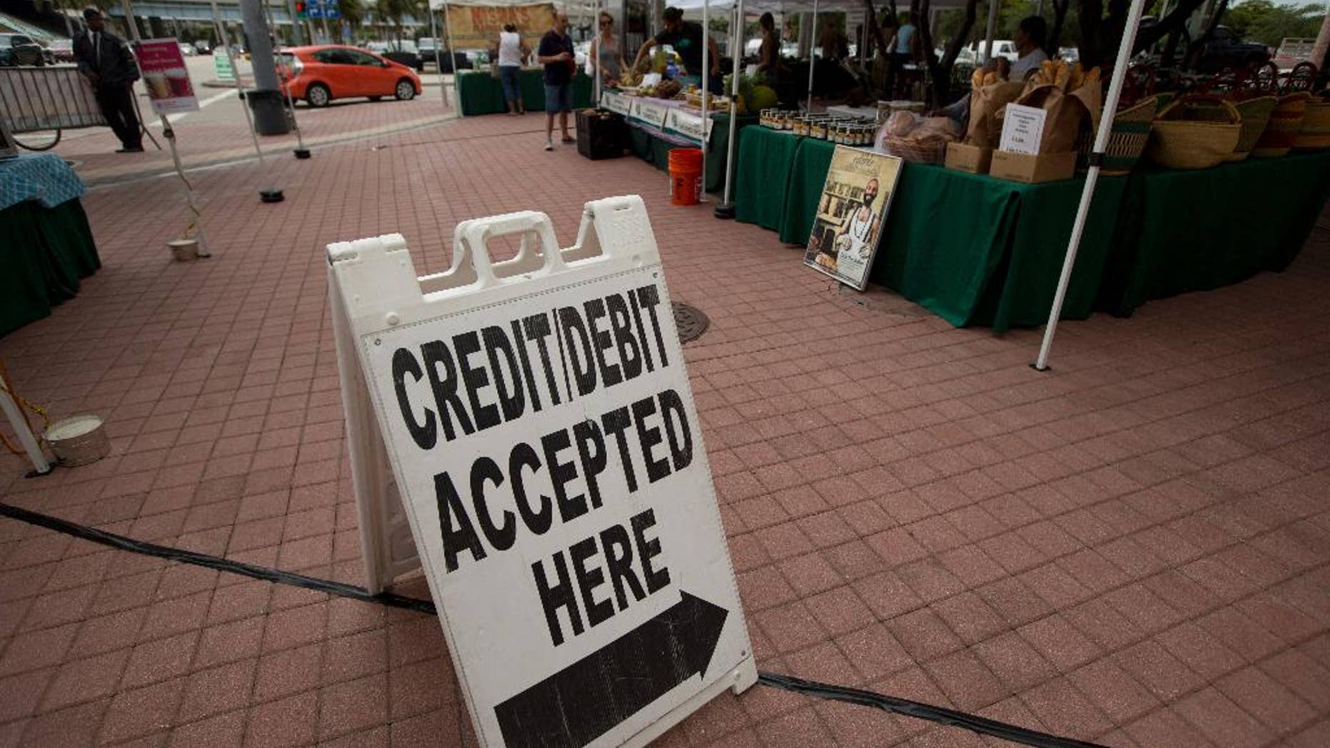 In this June 8, 2015 photo, credit card customers are directed to a pay station at the green market in downtown Miami. The Federal Reserve releases consumer credit data for June on Friday, Aug. 7, 2015. (AP Photo/J Pat Carter)