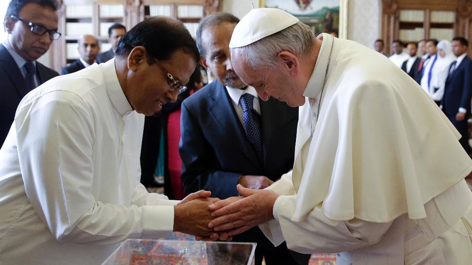 Pope Francis shakes hands with President Maithripala Sirisena at the end of a private audience at the Vatican, Monday, Dec. 14, 2015. (AP Photo/Gregorio Borgia, Pool)