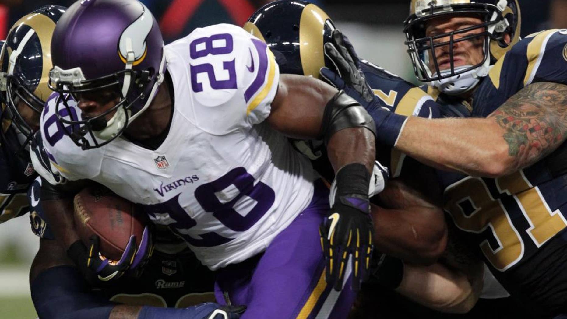 Minnesota Vikings running back Adrian Peterson (28) runs for a 5-yard gain as St. Louis Rams defensive end Chris Long, right, defends during the first quarter an NFL football game Sunday, Sept. 7, 2014, in St. Louis. (AP Photo/Tom Gannam)