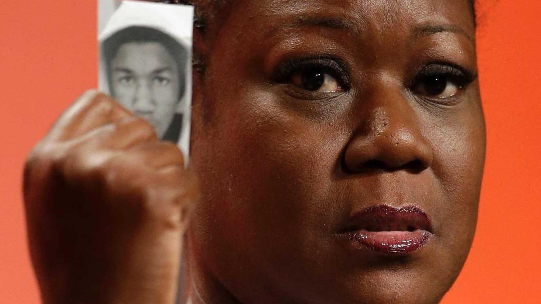 FILE - In this July 26, 2013, file photo, Sybrina Fulton, mother of Trayvon Martin, holds up a card with a photo of her son as she speaks at the National Urban League's annual conference in Philadelphia. A university will award Martin a posthumous Bachelor of Science Degree in aviation five years after the black teenager was fatally shot by a neighborhood watch volunteer in a central Florida neighborhood. An announcement on Florida Memorial University's official Facebook page says Martin's parents, Fulton and Tracy Martin, will accept the degree during a May 13, 2017, commencement ceremony. Fulton graduated from the Miami Gardens university and, along with Tracy Martin, co-founded the Trayvon Martin Foundation. (AP Photo/Matt Rourke, File)