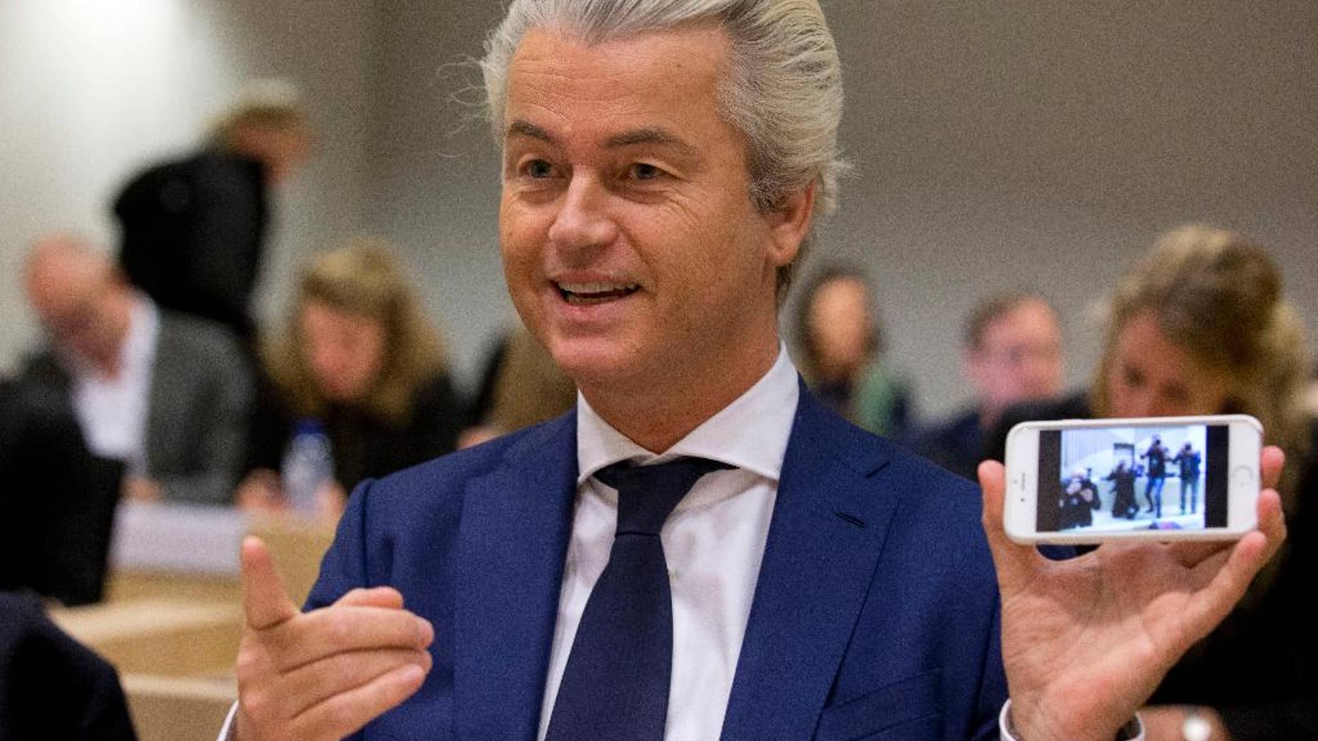 In this Friday March 18, 2016 file photo Populist anti-Islam lawmaker Geert Wilders shows a picture he took of the photographers as he appeared in court for a pretrial hearing at a high-security court on charges of inciting hatred, in Amsterdam, Netherlands. Wilders was in court Friday Sept. 23 for a pre-trial hearing in his hate speech prosecution. (AP Photo/Peter Dejong)
