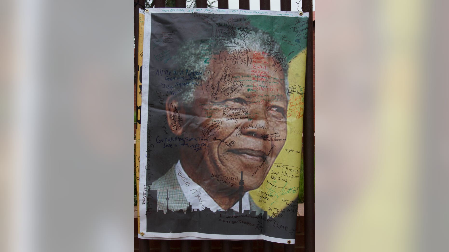 A giant signed poster with messages of support is attached to the former Soweto home, turned museum, of former South African president Nelson Mandela, Soweto, South Africa, Friday Dec. 6 2013. Mandela passed away Thursday night after a long illness. He was 95. As word of Mandela's death spread, current and former presidents, athletes and entertainers, and people around the world spoke about the life and legacy of the former South African leader. (AP Photo/Athol Moralee)