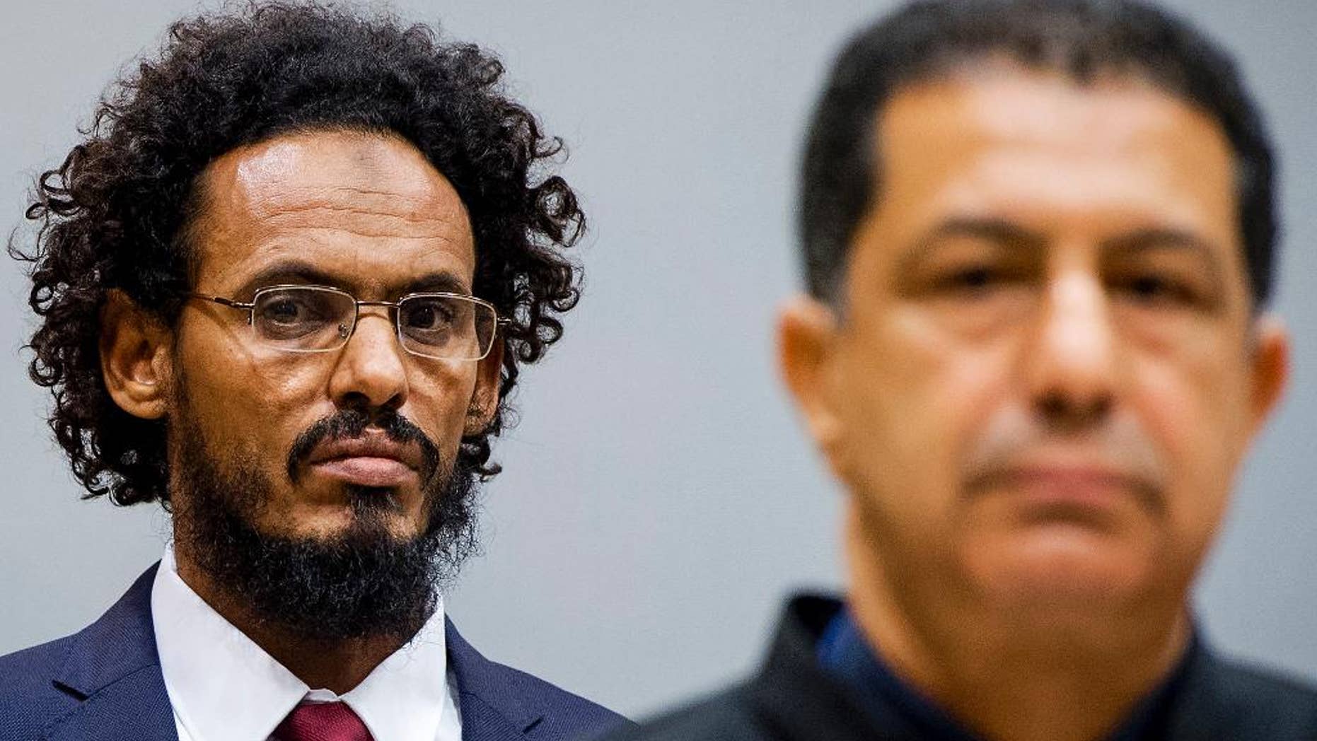 Ahmad Al Mahdi Al Faqi, left, enters the court room for his initial appearance at the International Criminal Court in The Hague, Netherlands, Wednesday, Sept. 30, 2015. Al Faqi, an alleged Islamic radical, is the first suspect in the court's custody charged with the war crime of deliberately attacking and destroying religious or historical monuments in Timbuktu, Mali. (AP Photo/Robin van Lonkhuijsen, Pool)