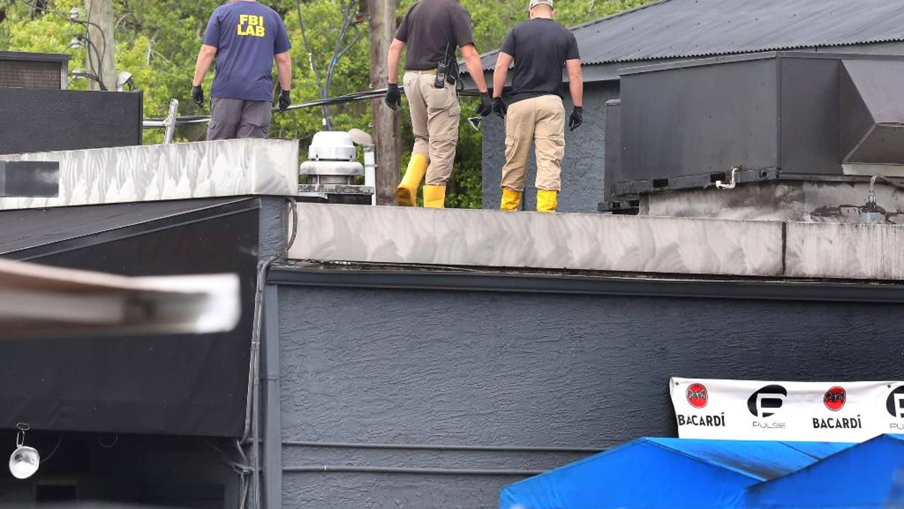 FBI lab personnel walk on the roof of the Pulse Nightclub June 20.