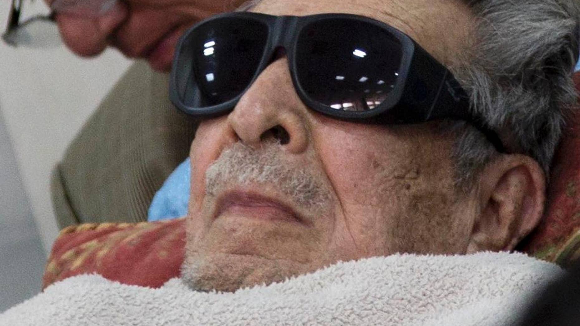FILE - In this Jan. 5, 2015 file photo, Guatemala's former dictator Jose Efrain Rios Montt arrives on a gurney wearing sunglasses to court where he faces charges of genocide and crimes against humanity in Guatemala City. A Guatemalan court ordered on Thursday, July 23, 2015, Rios Montt be put in a psychiatric hospital for nine days’ observation, delaying his possible retrial on genocide charges. The court order seeks to evaluate the 89-year-old ex-general's mental and physical health following a report that found him incompetent to stand trial. (AP Photo/Luis Soto, File)