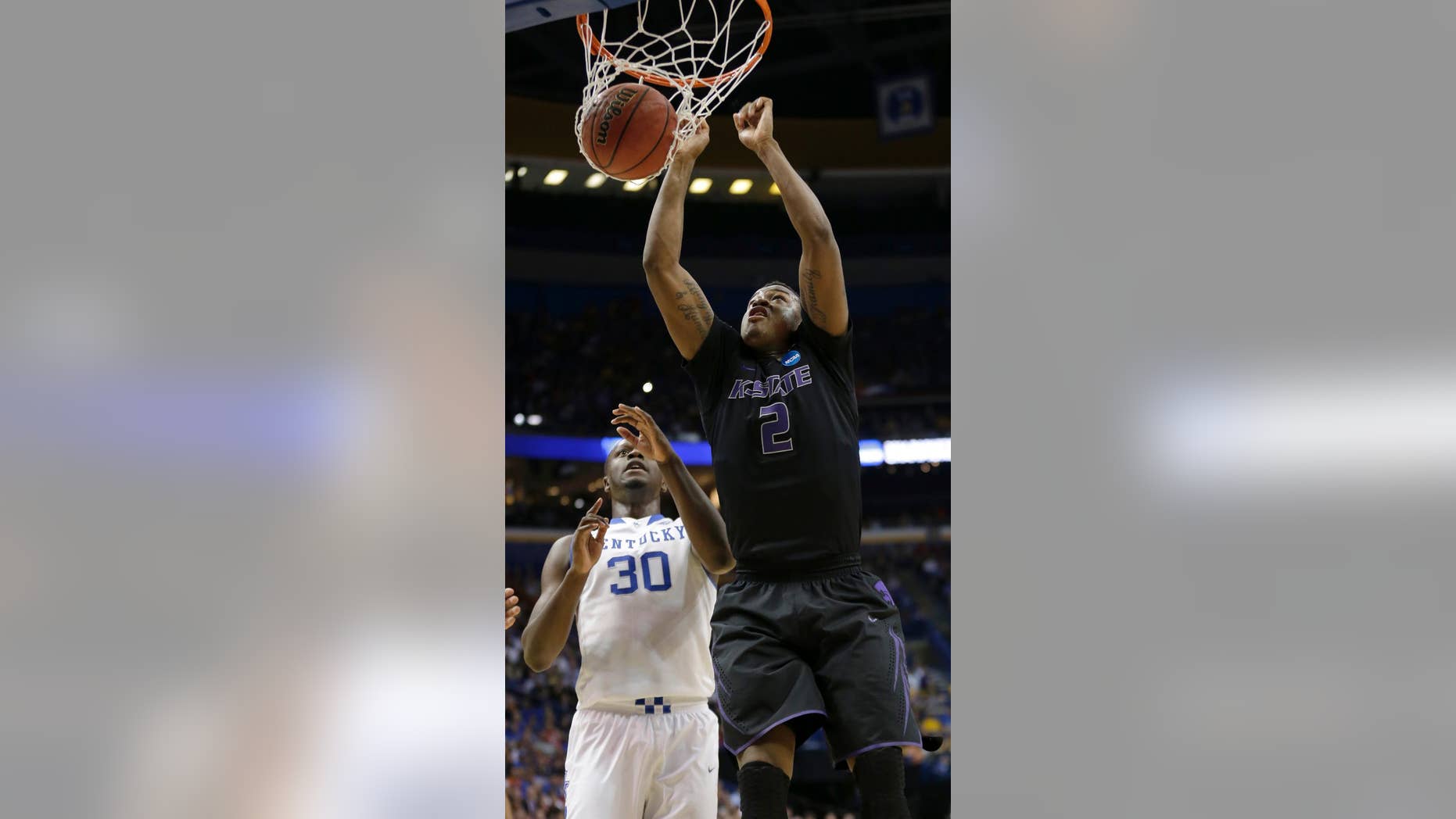 Kansas State's Marcus Foster (2) gets past Kentucky's Julius Randle (30) to dunk the ball during the first half of a second-round game in the NCAA college basketball tournament, Friday, March 21, 2014, in St. Louis. (AP Photo/Charlie Riedel)