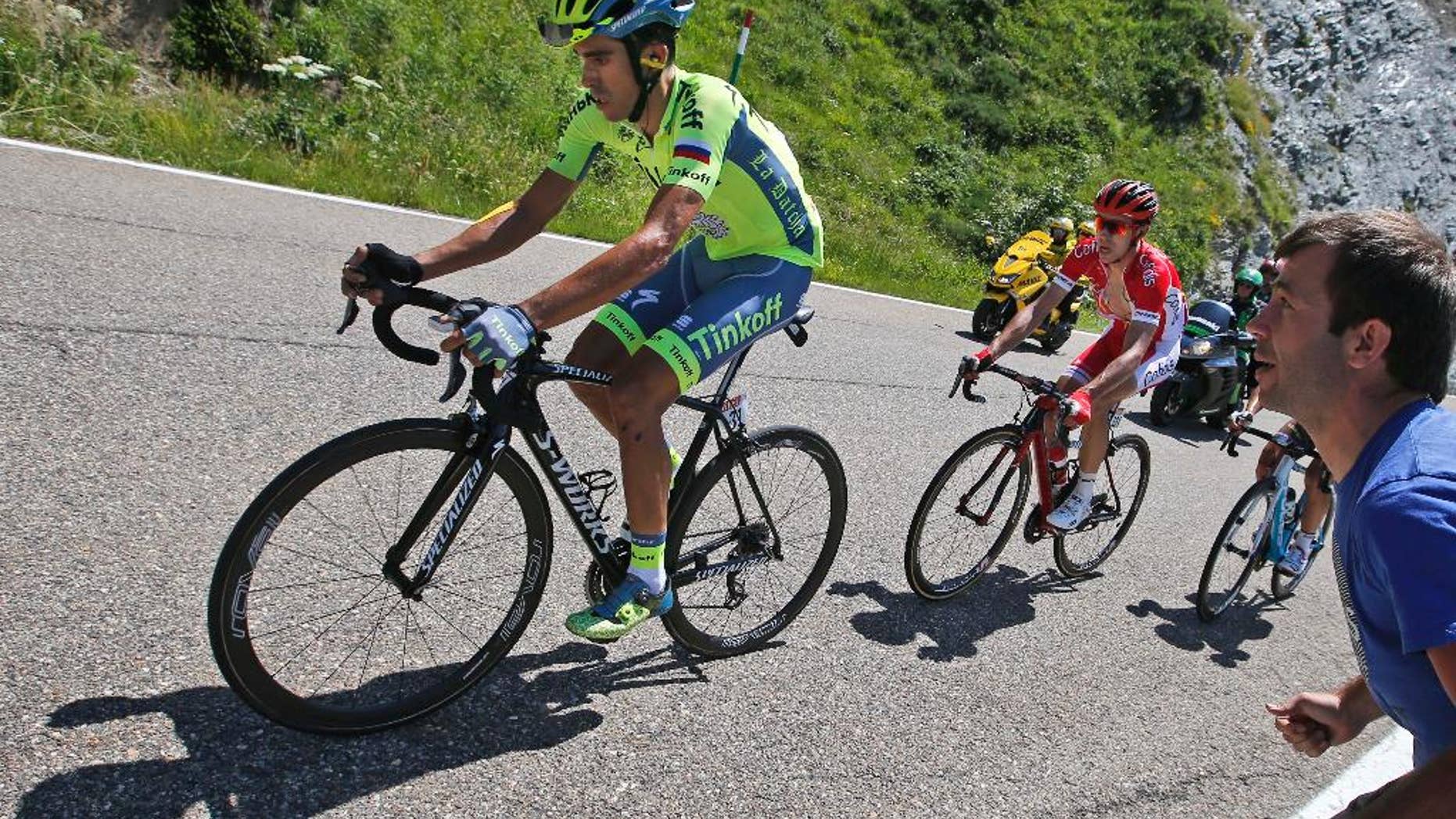Spain's Alberto Contador, left, strains as he rides in the back of the pack with France’s Nicolas Edet, right, during the ninth stage of the Tour de France cycling race Sunday.