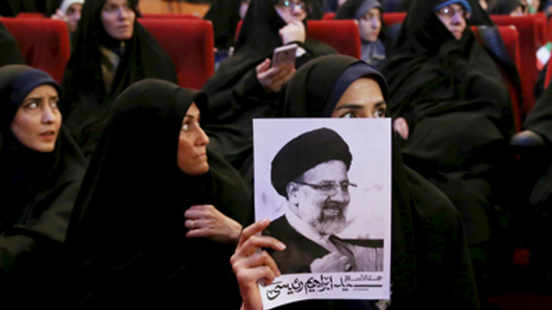 An Iranian holds up a poster of Iranian cleric Ebrahim Raisi, a conservative presidential candidate in the upcoming presidential election, at a campaign rally in Tehran, Iran, Wednesday, April 26, 2017. (AP Photo/Ebrahim Noroozi)