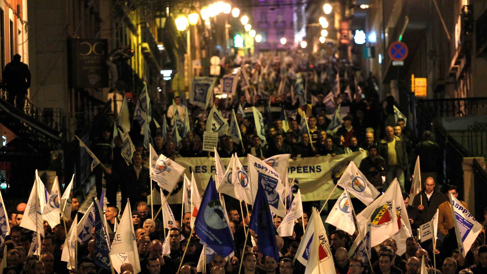 People march towards the Portuguese parliament during a protest by Portuguese national security forces unions and professional associations, in Lisbon, Thursday, Nov. 21, 2013. The strike is against austerity measures that the Portuguese government plans to include in the 2014 national budget. (AP Photo/Francisco Seco)