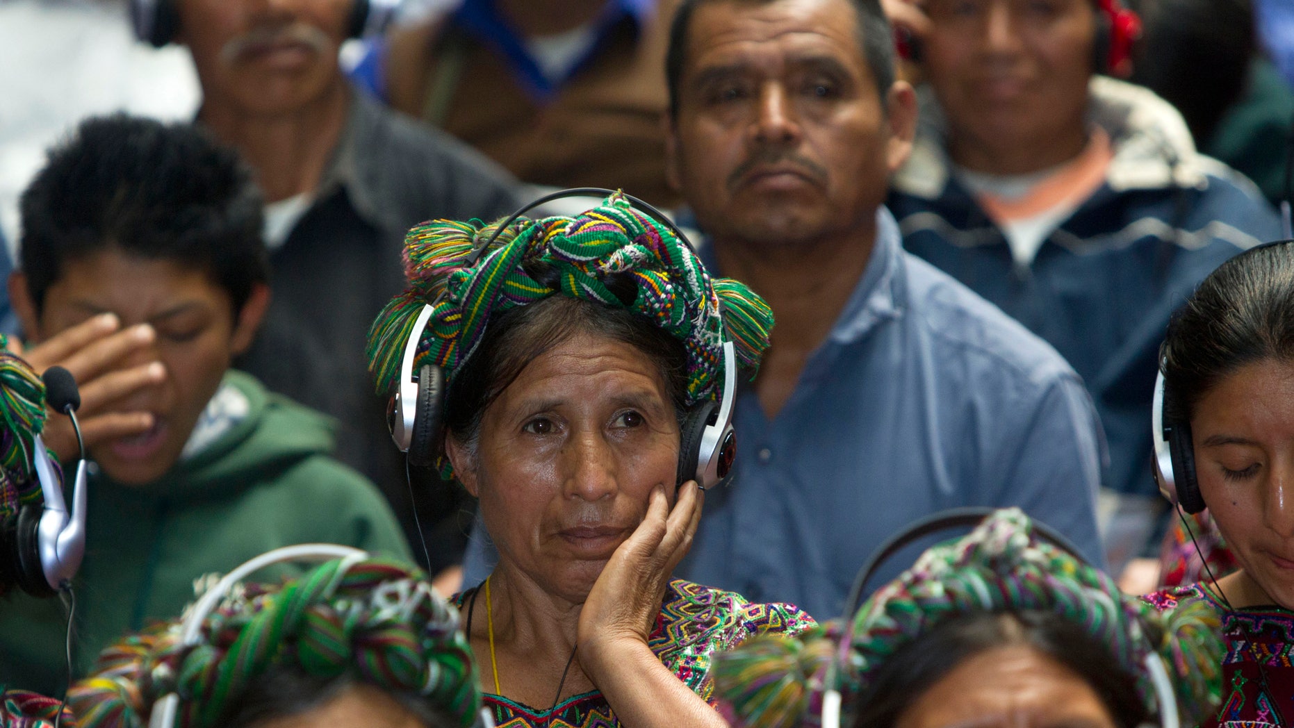 An Ixil Indian woman, the relative of a civil war victim, uses earphones to hear translations between Spanish and the Ixil language during the genocide trial of former dictator Jose Efrain Rios Montt in Guatemala City, Thursday, May 9, 2013. The 86-year-old ex-general says he never ordered attacks against "a race,"denying he ordered the extermination of Ixil Mayas. Prosecutors say that while in power, Rios Montt was aware of, and thus responsible for, the slaughter of at least 1,771 Ixil Mayas in the towns of San Juan Cotzal, San Gaspar Chajul and Santa Maria Nebaj in Guatemala's western highlands. (AP Photo/Moises Castillo)