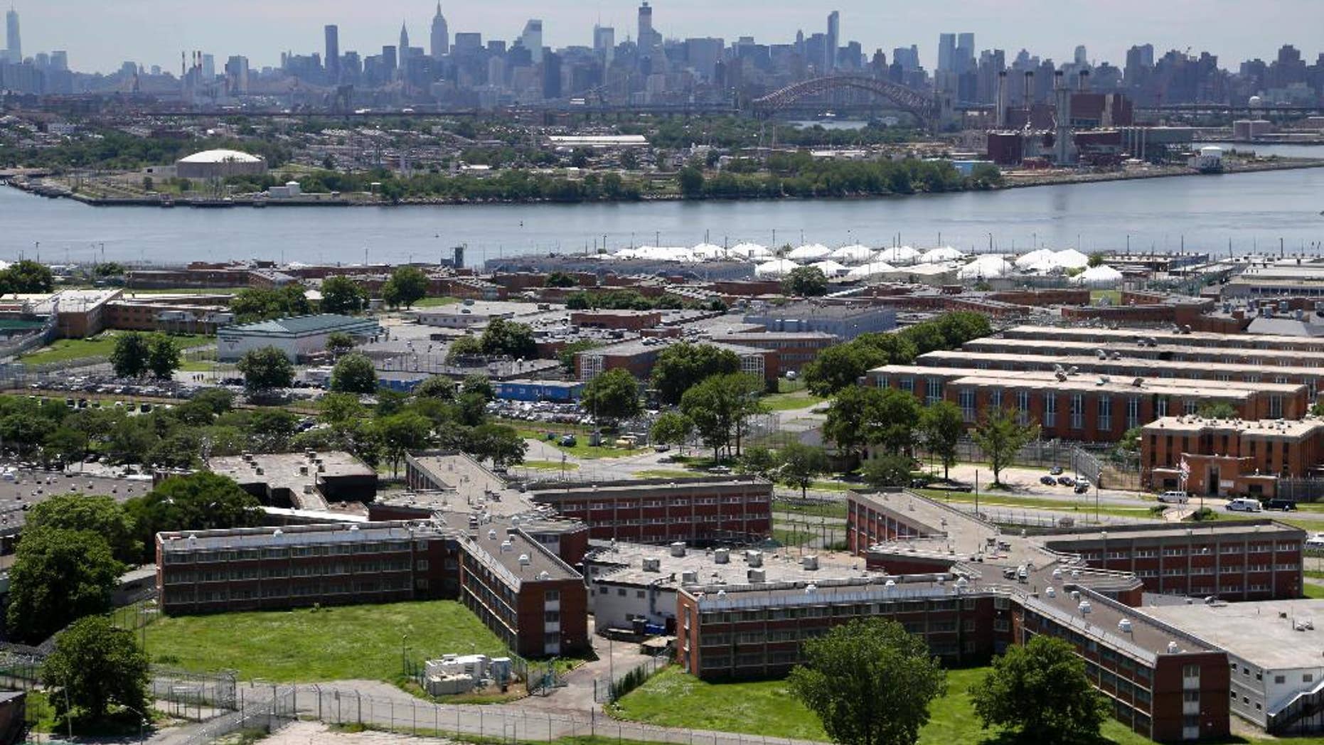 FILE - In a June 20, 2014, file photo, the Rikers Island jail complex stands in New York with the Manhattan skyline in the background. Two correction officers at New York’s Rikers Island have been assaulted by two inmates. It happened Tuesday evening, Oct. 4, 2016, at the Otis Bantum Correctional Center inside the jail complex. Both officers were taken to a hospital, where they were treated and released. (AP Photo/Seth Wenig, File)