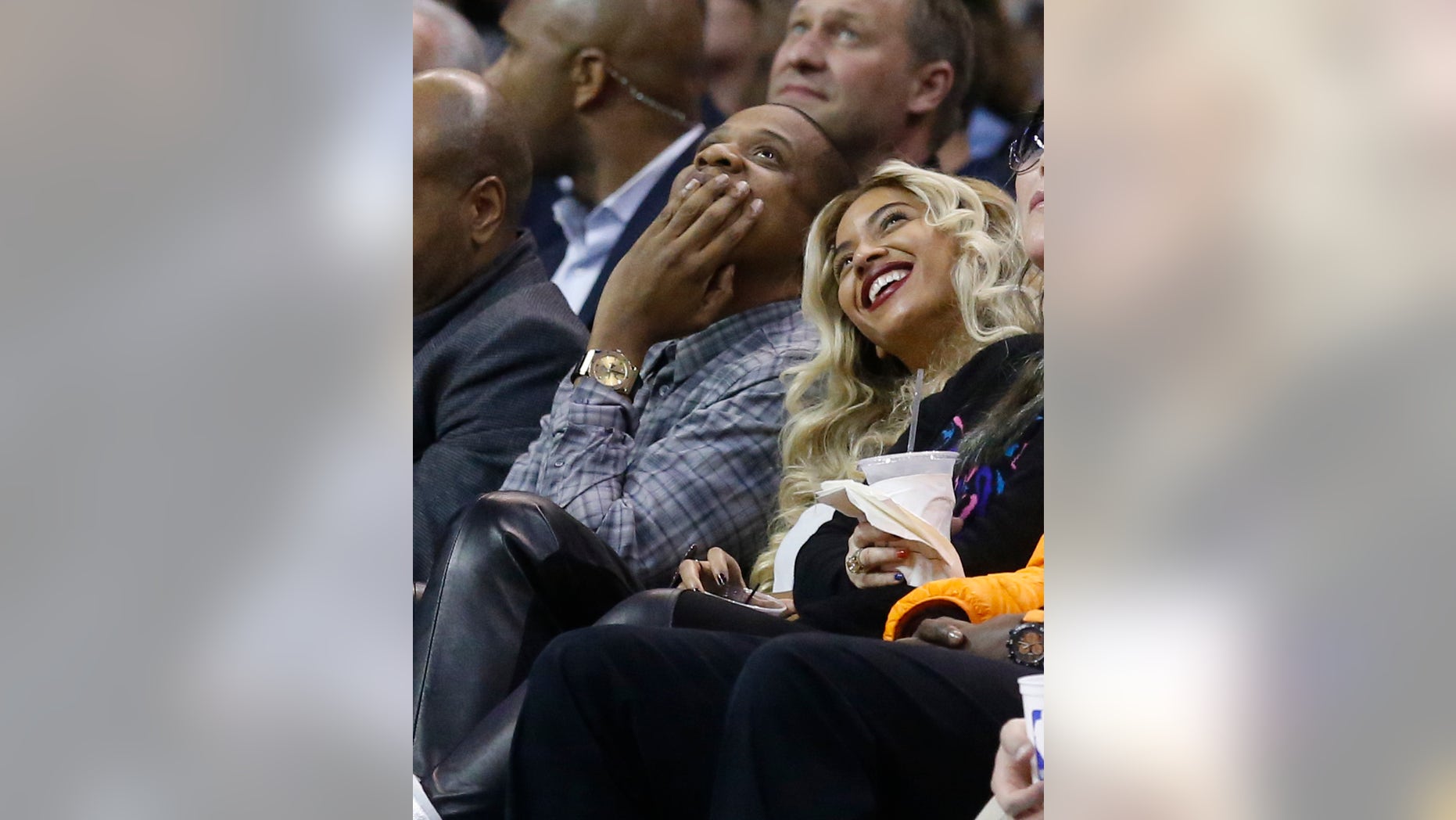 Jay-Z, left, and Beyonce look up at the scoreboard during an NBA basketball game between the Oklahoma City Thunder and the Los Angeles Clippers in Oklahoma City, Thursday, Nov. 21, 2013. (AP Photo/Sue Ogrocki)