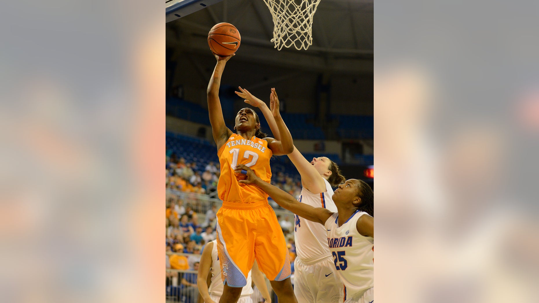 Tennessee's Bashaara Graves (12) goes for two points with Florida center Vicky McIntyre (34) and Florida forward Christin Mercer (25) try to block the shot during the first half of an NCAA college basketball game in Gainesville, Fla., Sunday, Jan. 13, 2013. (AP Photo/Phil Sandlin)