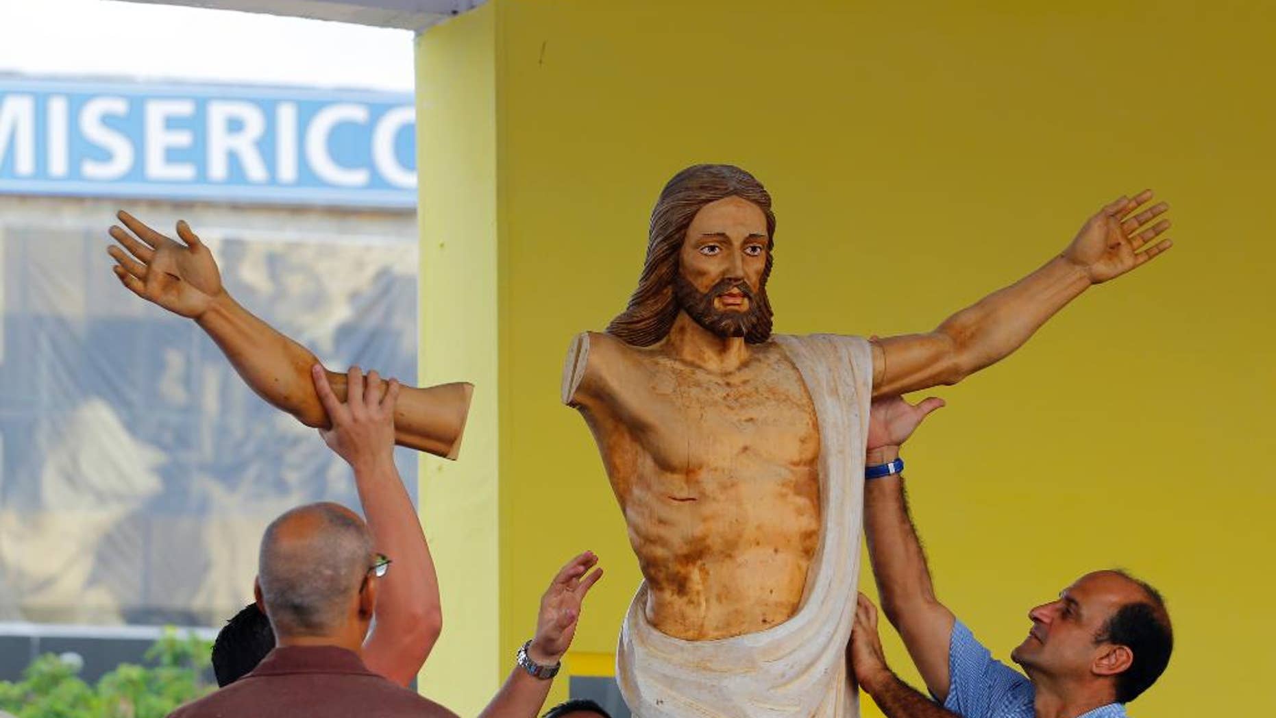 Workers fit an arm onto a Christ statue during preparations of the altar where Pope Francis will celebrate Mass in the Plaza of the Revolution, in Havana, Cuba, Thursday, Sept. 17, 2015. When Francis arrives in Havana on Sept. 19, he'll find his church ministering to more Cubans than at any time since the 1959 revolution that brought Fidel Castro to power. (AP Photo/Desmond Boylan)