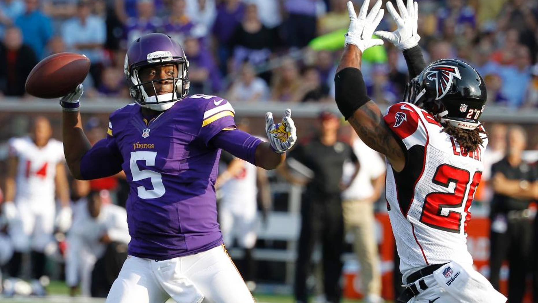 Minnesota Vikings quarterback Teddy Bridgewater (5) looks to pass over Atlanta Falcons free safety Dwight Lowery during the first half of an NFL football game, Sunday, Sept. 28, 2014, in Minneapolis. (AP Photo/Ann Heisenfelt)