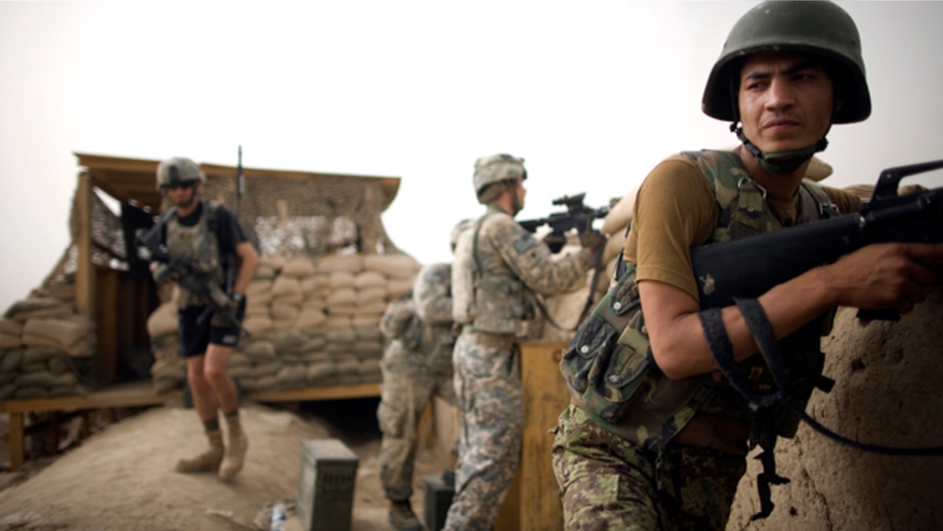 July 23, 2010: Afghan National Army soldiers and U.S. Army soldiers from the 1-320th Alpha Battery, 2nd Brigade of the 101st Airborne Division stand guard after an insurgent attack at COP Nolen, in the volatile Arghandab Valley, Kandahar, Afghanistan.