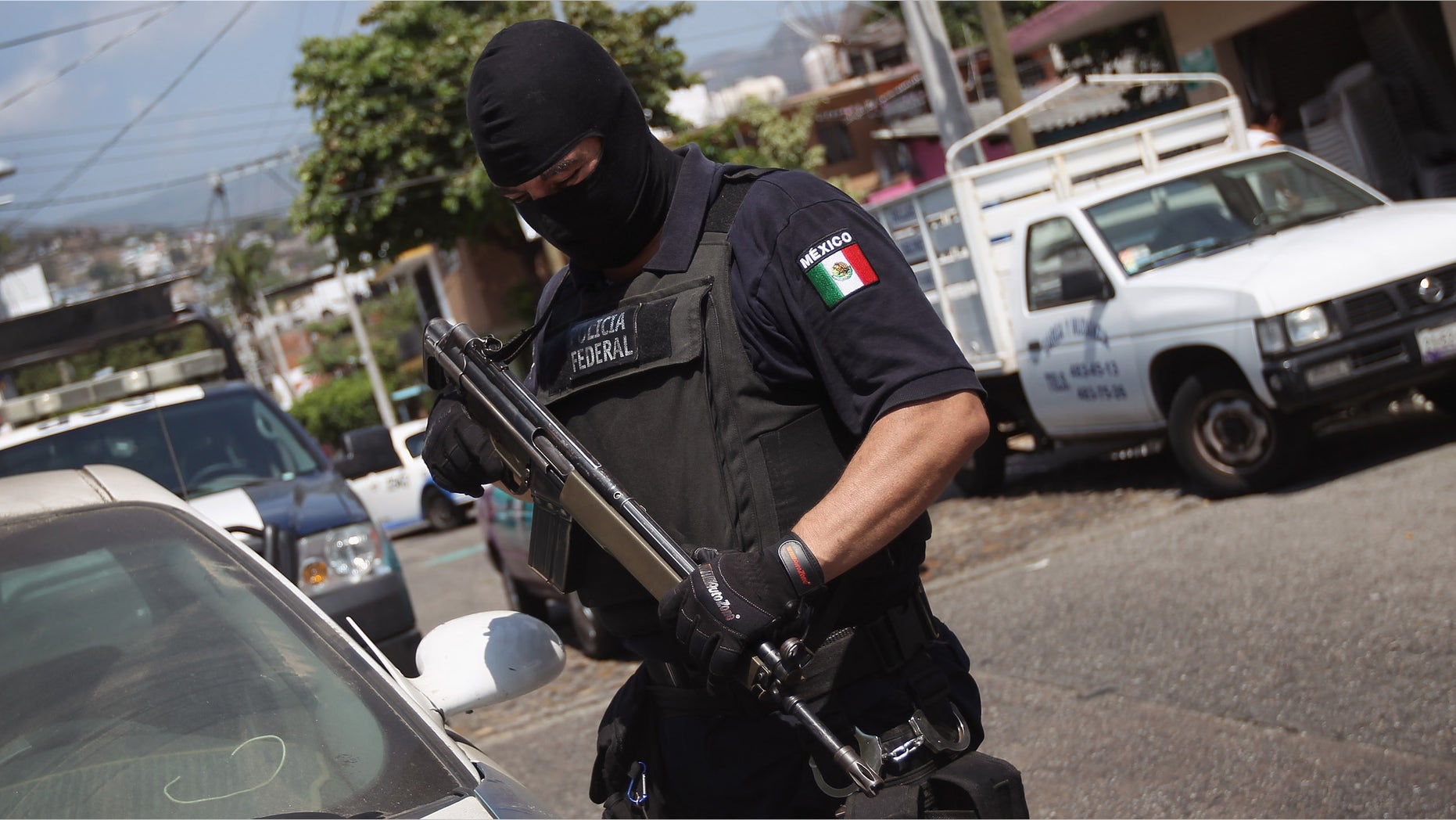 ACAPULCO, MEXICO - MARCH 01: A Mexican federal policeman inspects an abandoned car on March 1, 2012 in Acapulco, Mexico. Stolen vehicles used by drug gangs are often found abandoned throughout the city. Drug violence surged in the coastal resort last year, making Acapulco the second most deadly city in Mexico after Juarez. One of Mexico's top tourist destinations, Acapulco has suffered a drop in business, especially from foreign tourists, due to reports of the violence. Toursim accounts for some 9 percent of Mexico's economy and about 70 percent of the output of Acapulco's state of Guerrero. (Photo by John Moore/Getty Images)