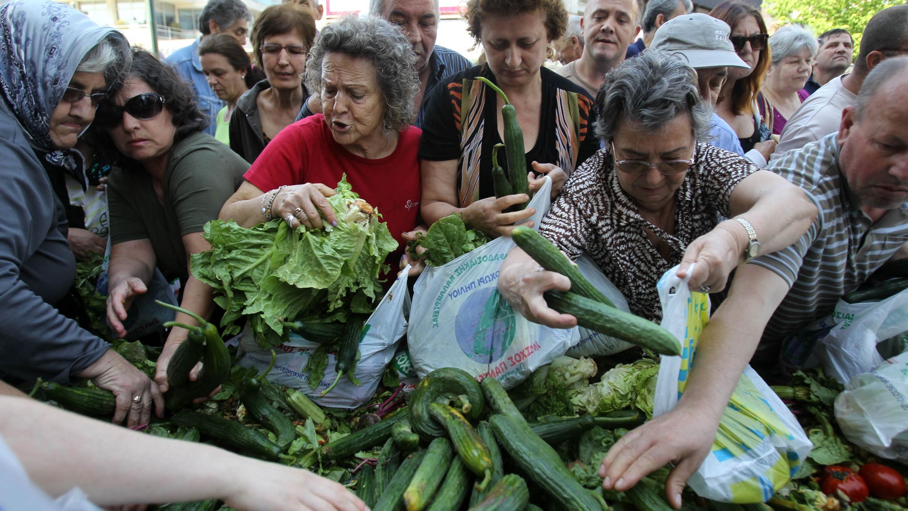 People reach out for fresh produce distributed by Greek street fruit and vegetable market vendors during a protest in Athens, Wednesday, May 15, 2013. The union of Greek farmers markets went on strike, Wednesday, as protesters set up stands and started distributing vegetables to a fast growing crowd. The market vendors are the latest professional group in Greece to protest a sweeping market liberalization drive demanded by rescue creditors, and timed their protest to draft legislation due to be voted in parliament to implement the new guidelines. (AP Photo/Thanassis Stavrakis)