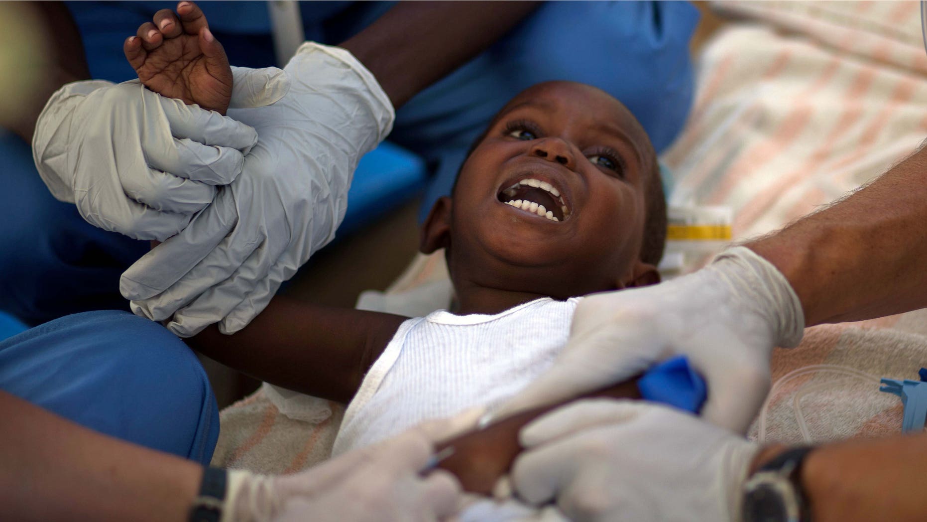 A child with cholera symptoms is treated by volunteer American doctors at a hospital in Archaie, Haiti, Monday Nov. 15, 2010. Nearly 1,000 people have been killed and thousands have been hospitalized for cholera across Haiti, with symptoms including serious diarrhea, vomiting and fever. (AP Photo/Ramon Espinosa)